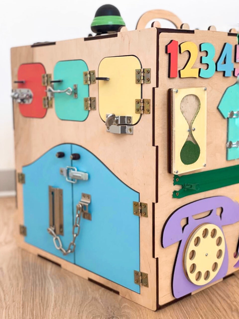 A colorful Busy Cube measuring 15 inches, featuring various engaging busy boards designed for children's skill development and creativity.