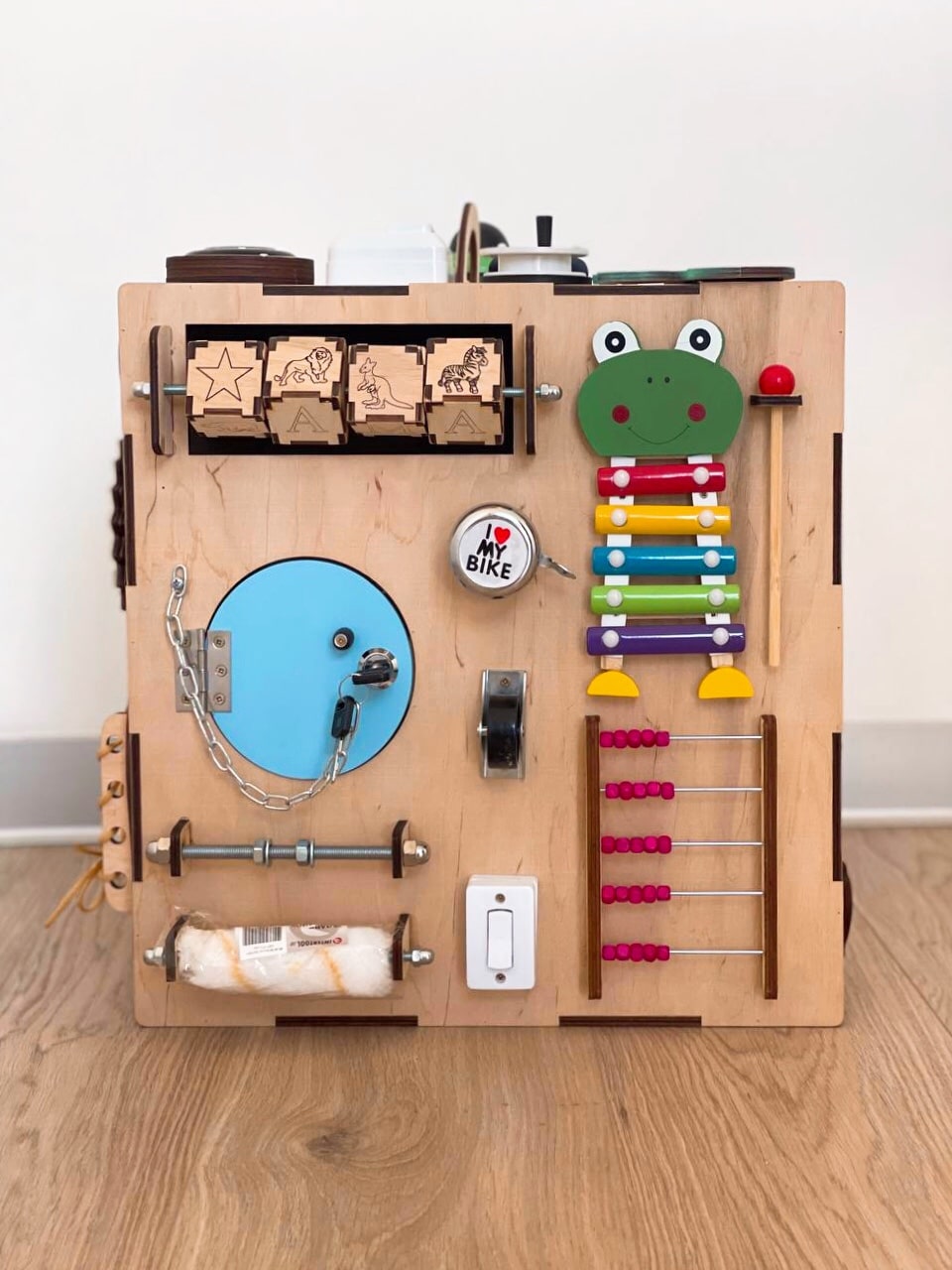 A colorful Busy Cube measuring 15 inches, featuring various engaging busy boards designed for children's skill development and creativity.