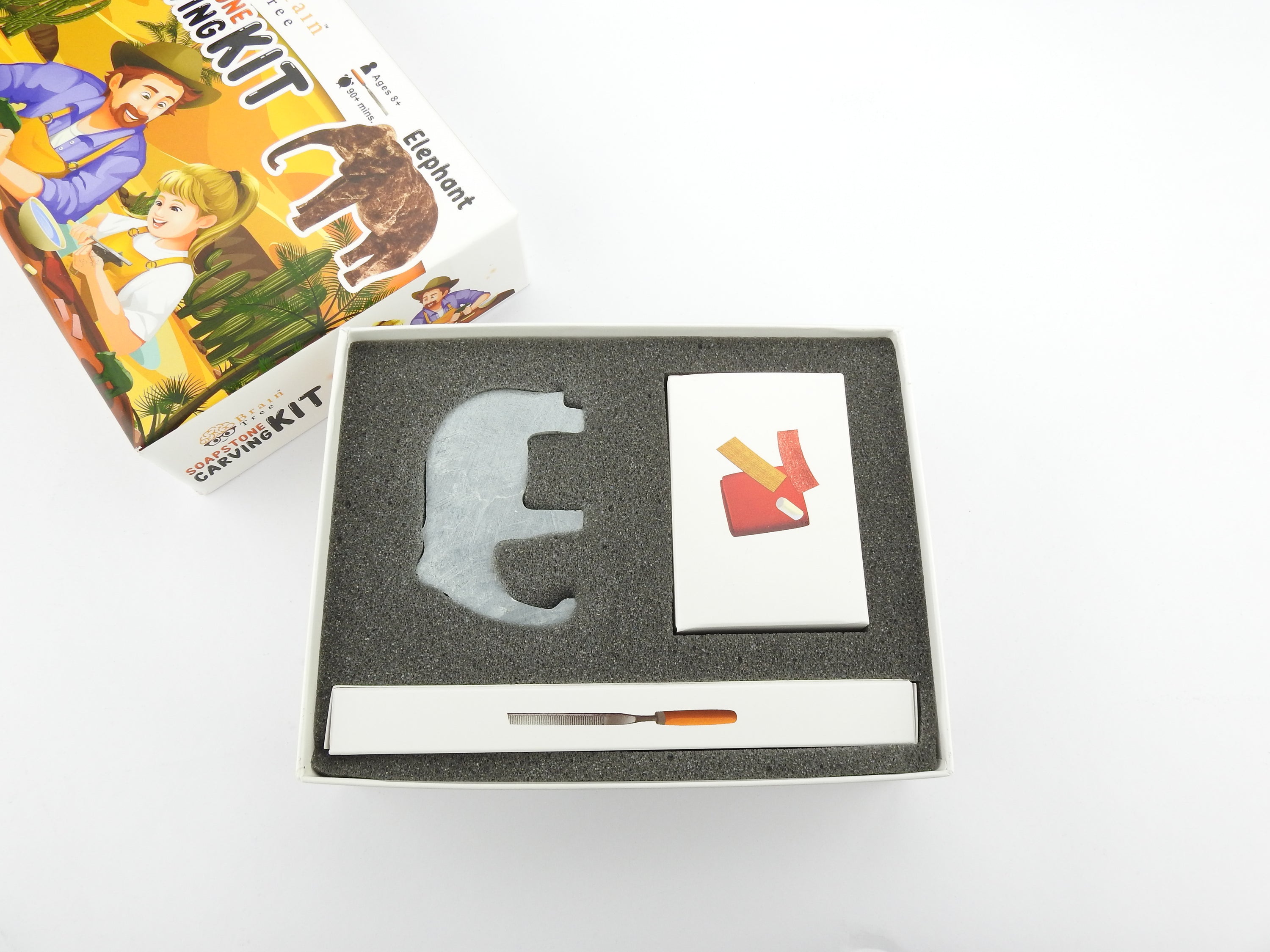 A complete Elephant Soapstone Carving Kit featuring precut soapstone, carving tools, sandpaper, wax, and a manual, ideal for kids and adults.
