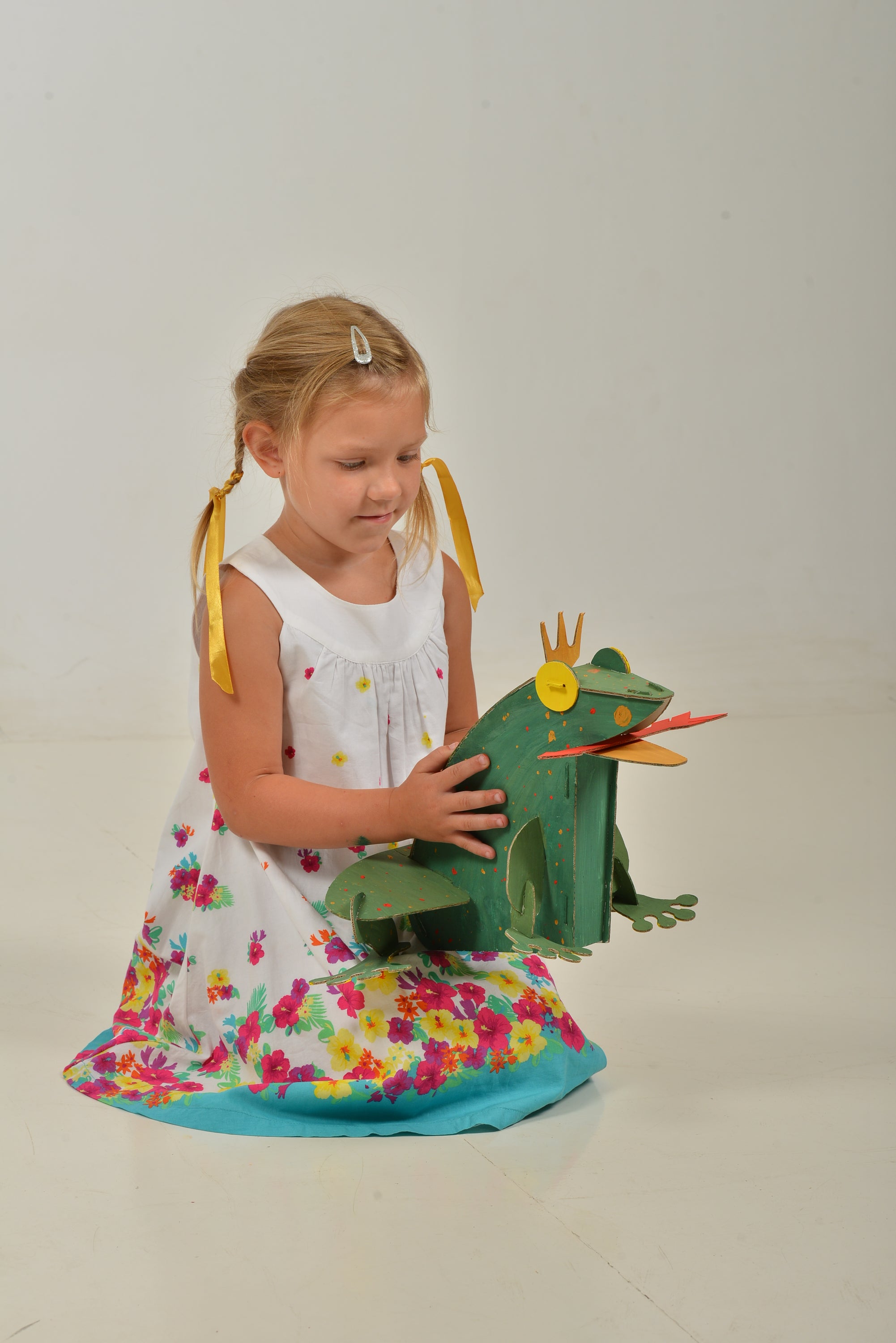 A colorful assembled cardboard frog model kit, showcasing its intricate parts and vibrant paint, perfect for children to build and decorate.