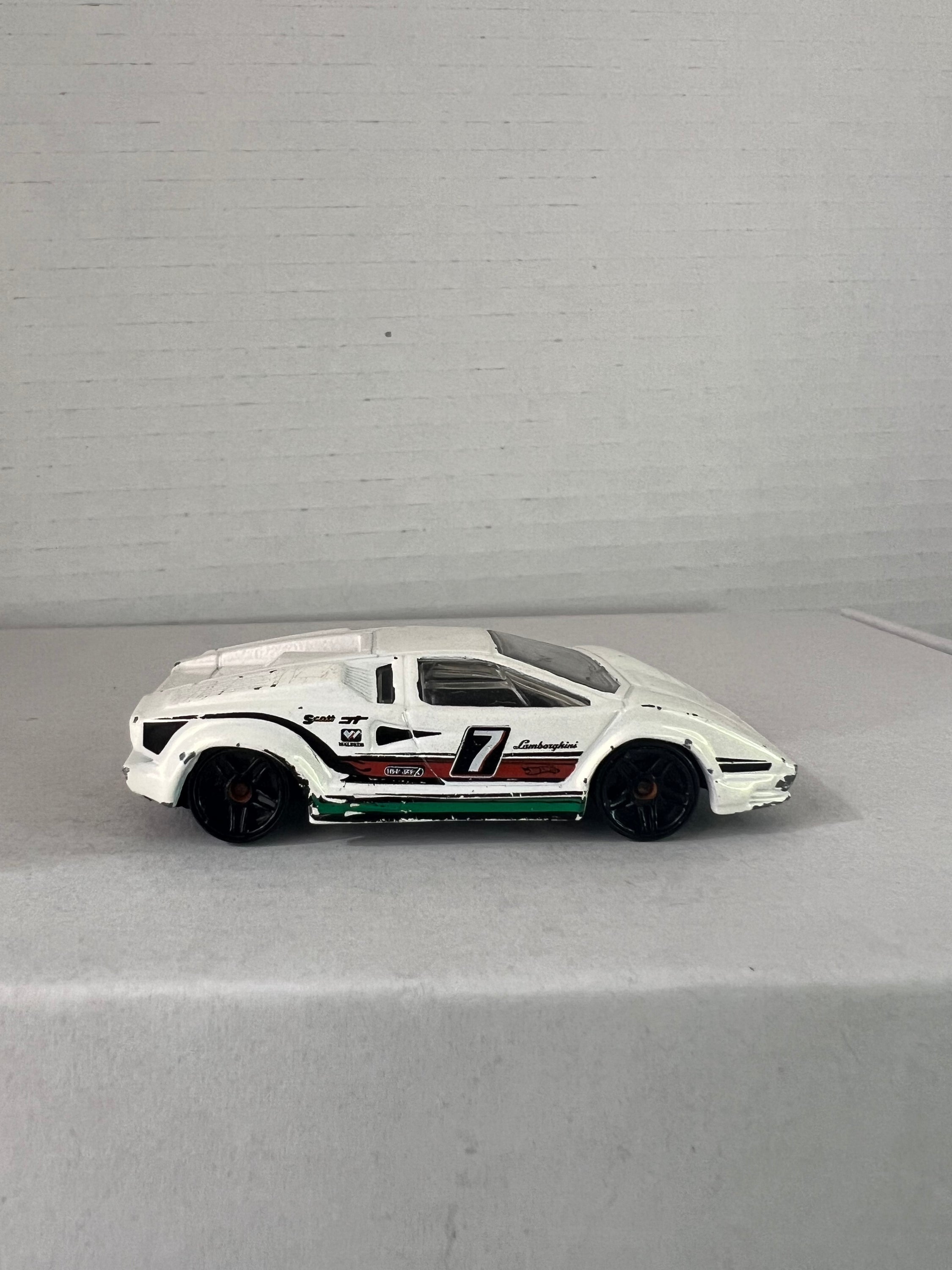 Hot Wheels 25th Anniversary Lamborghini Countach die-cast model in white, showcasing its sleek design and details.
