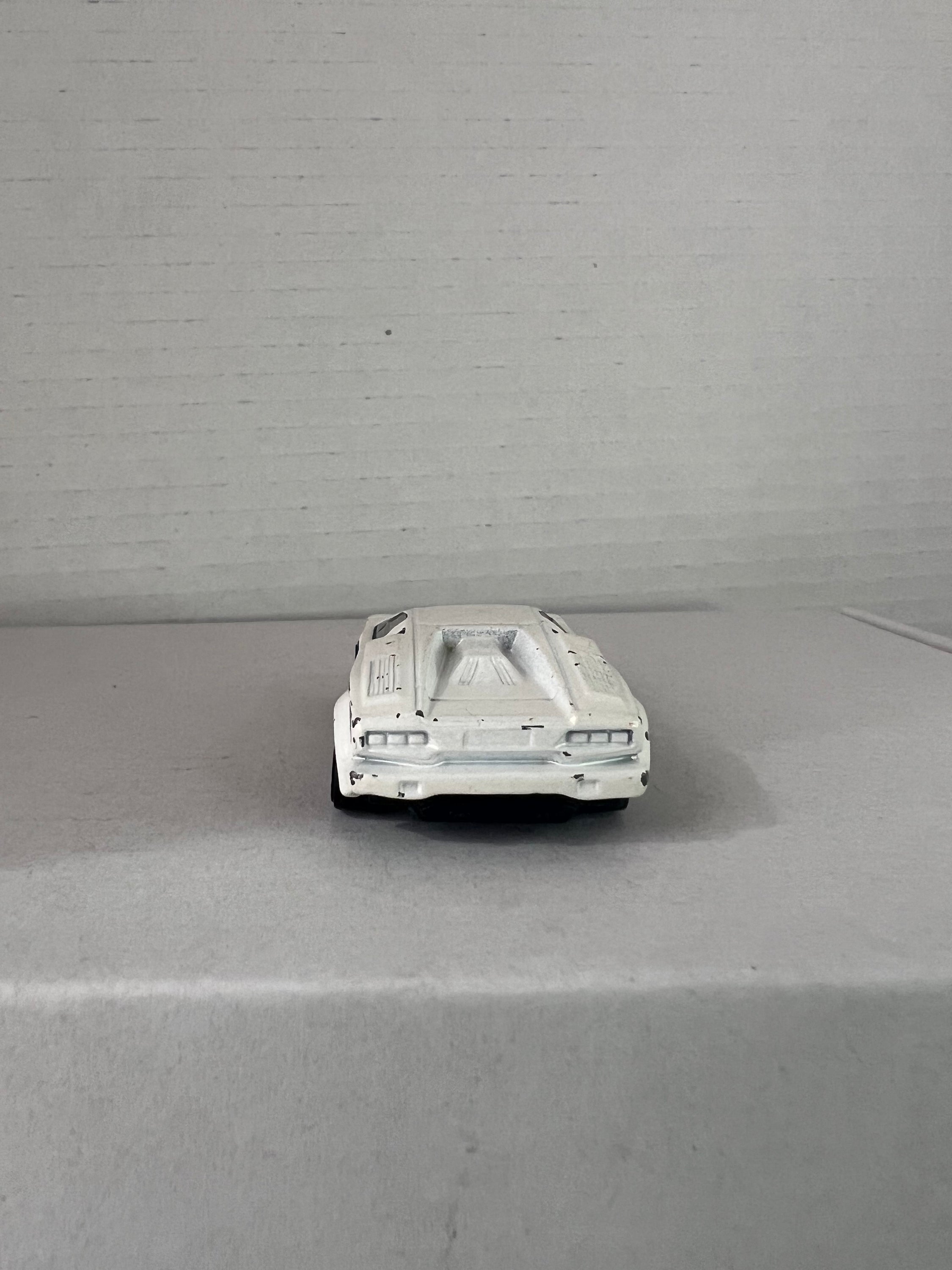 Hot Wheels 25th Anniversary Lamborghini Countach die-cast model in white, showcasing its sleek design and details.