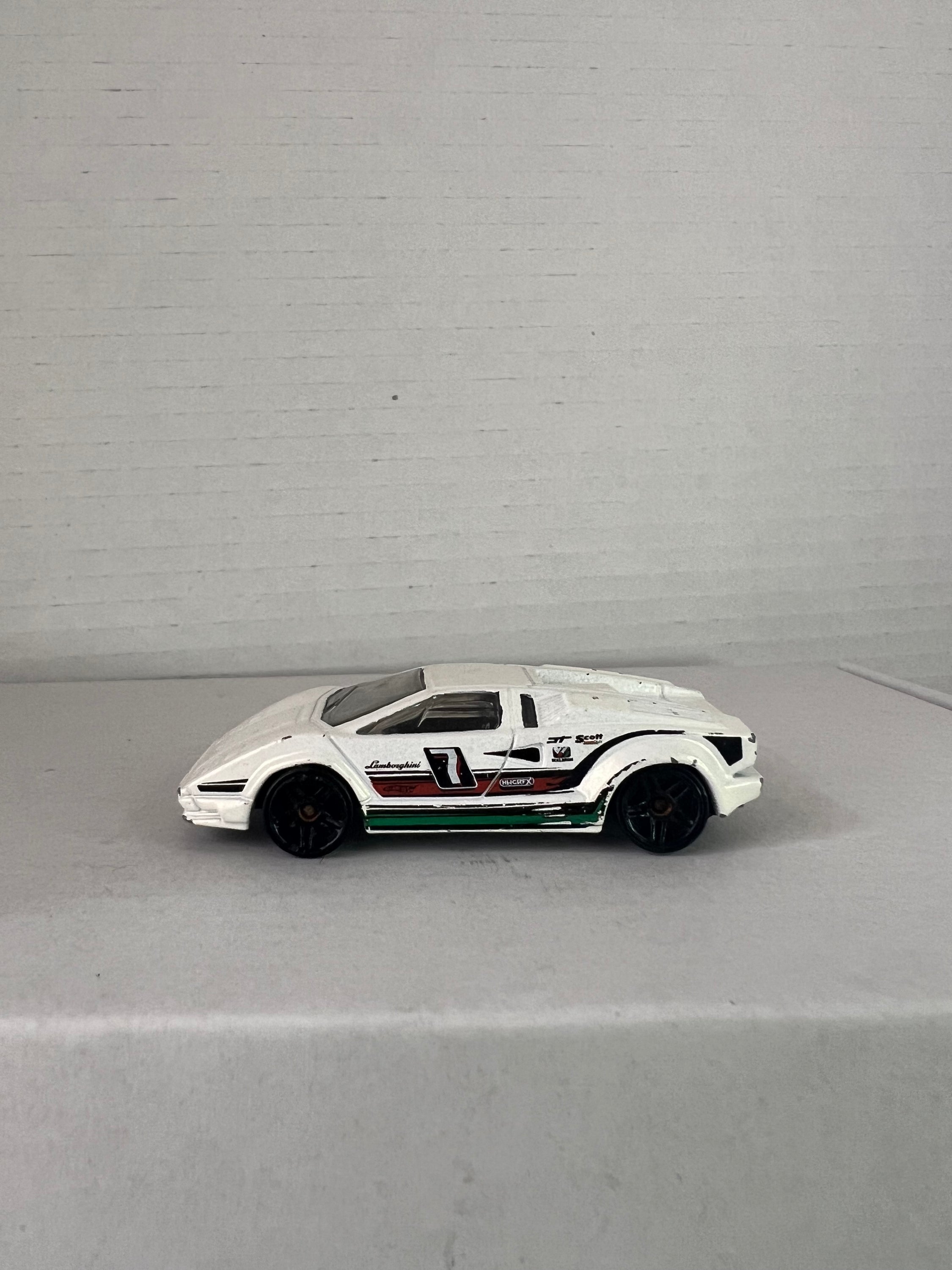 Hot Wheels 25th Anniversary Lamborghini Countach die-cast model in white, showcasing its sleek design and details.