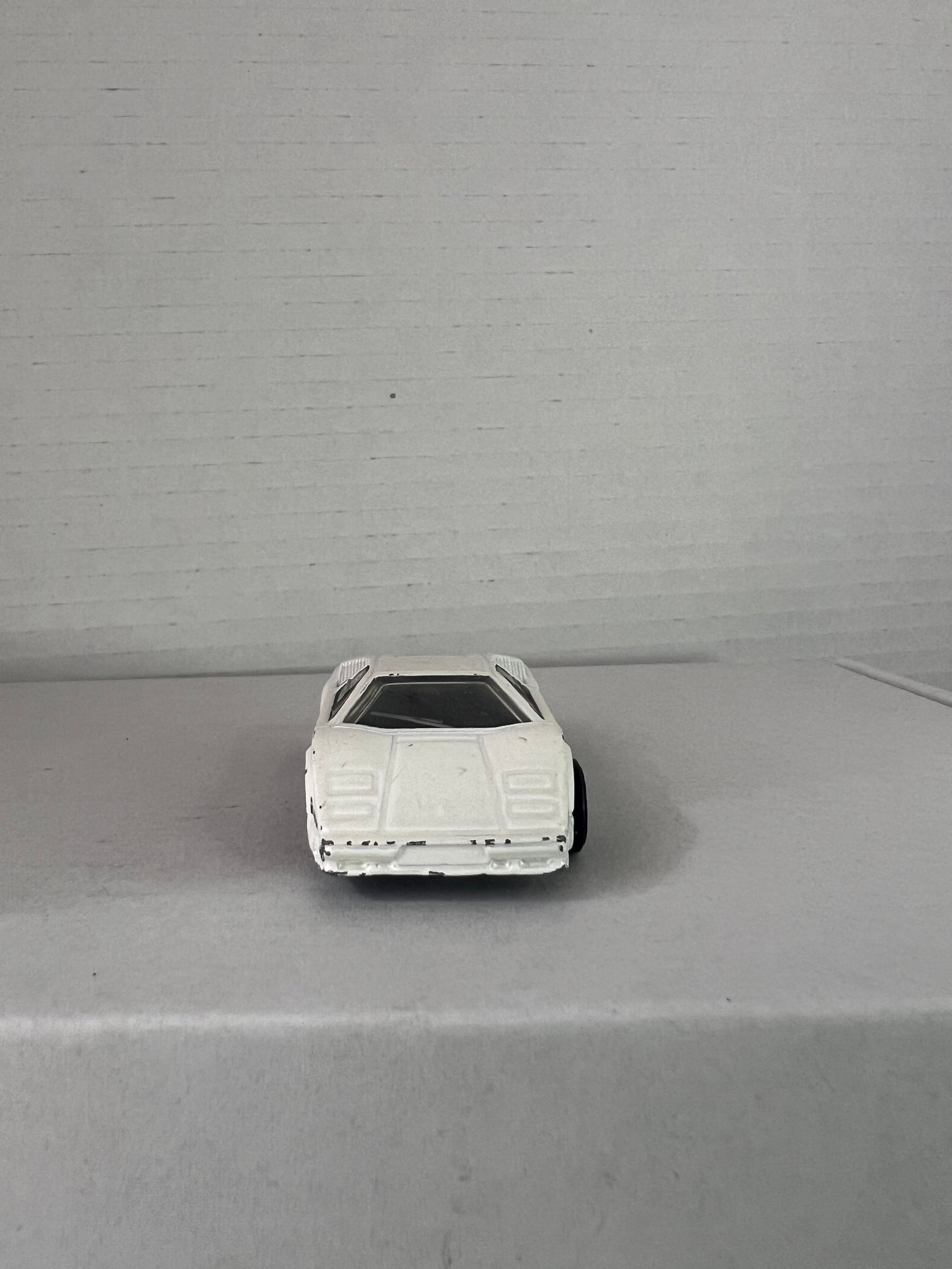 Hot Wheels 25th Anniversary Lamborghini Countach die-cast model in white, showcasing its sleek design and details.