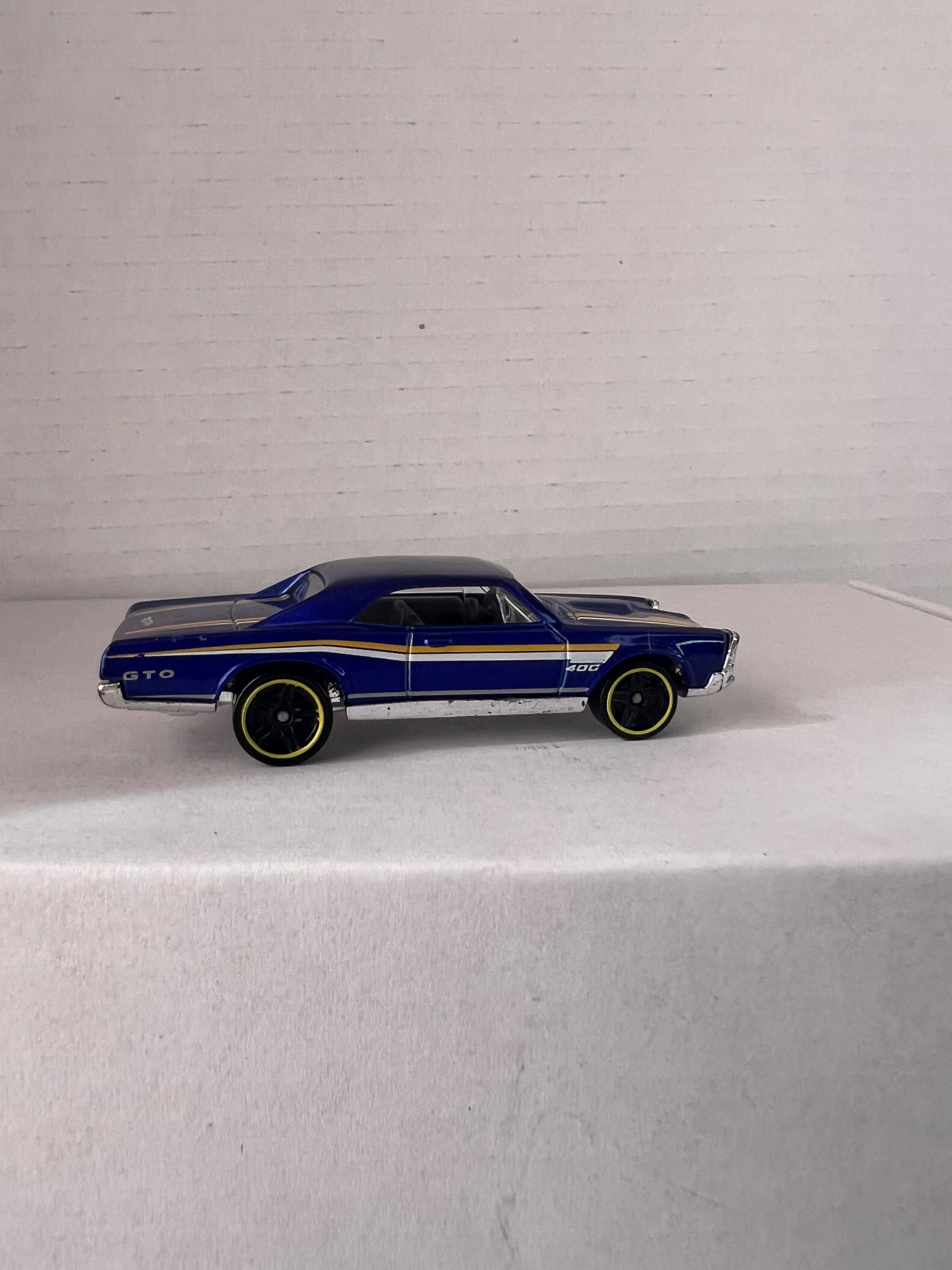 Hot Wheels HW Workshop (2015) set featuring '67 Pontiac GTO and '86 Monte Carlo SS die-cast cars in vibrant colors.