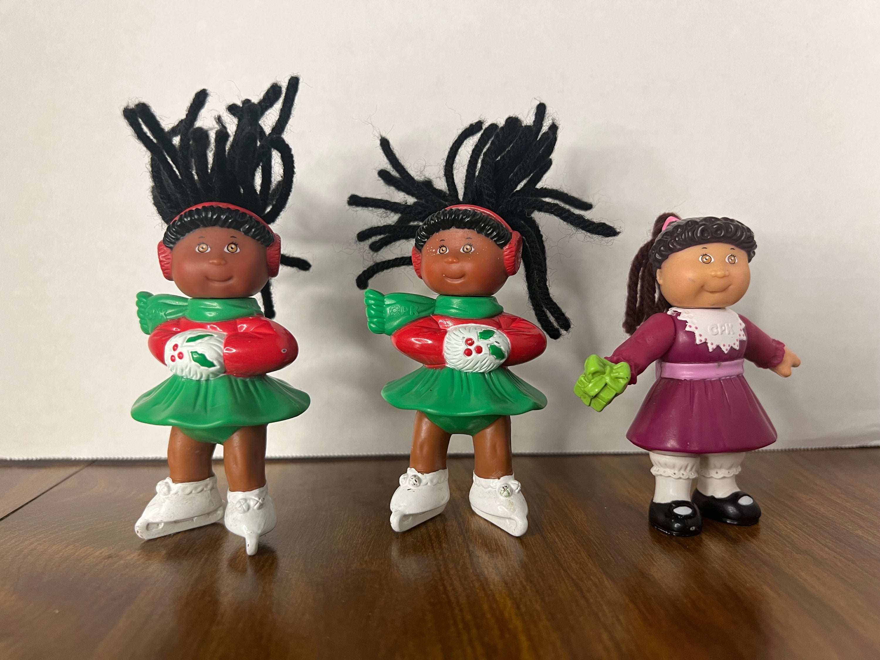 Three vintage McDonald's Happy Birthday Cabbage Patch Kids dolls from 1992, showcasing unique designs and minor paint wear.