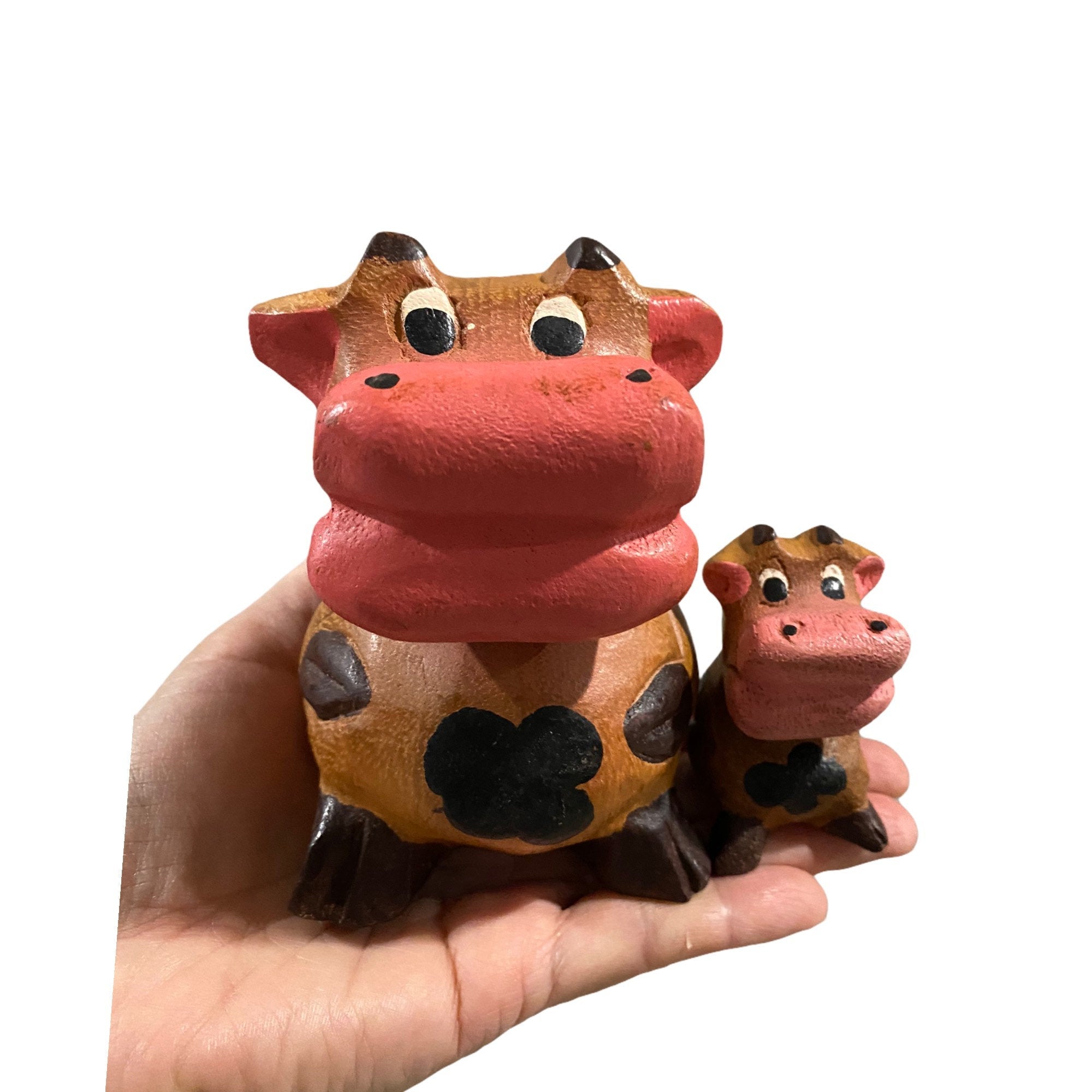 A hand-painted wooden musical whistle shaped like a cartoon cow, showcasing vibrant colors and intricate details, perfect for home decor.