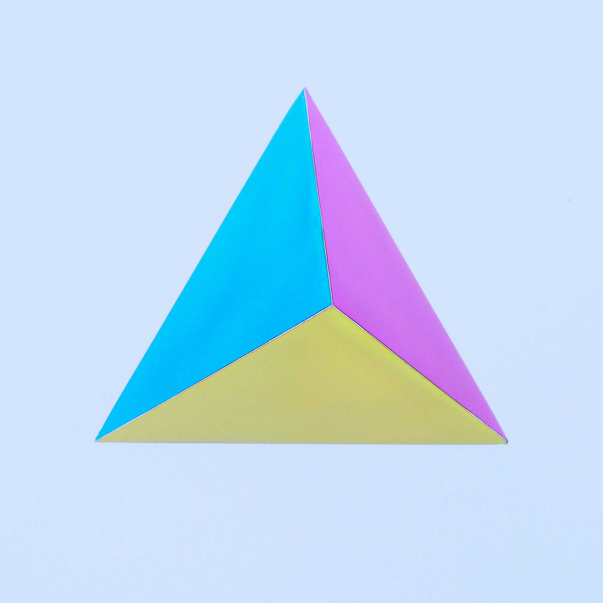 The Ignis CMY Tetrahedron showcasing vibrant colors and geometric design, featuring four triangular faces and six edges.