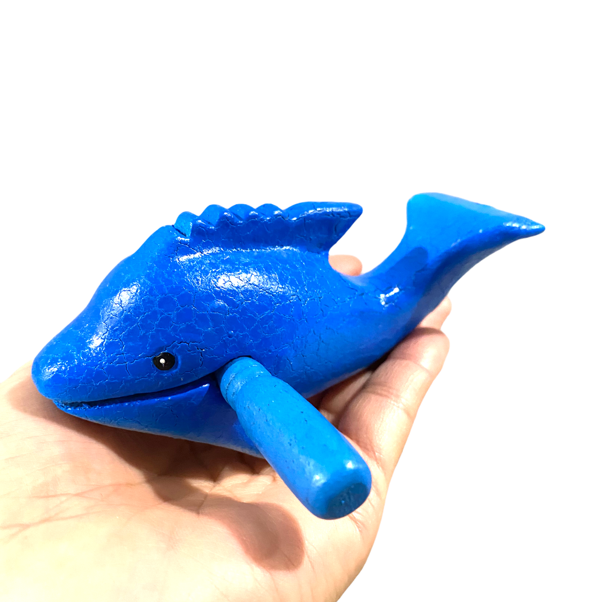 A handcrafted wooden dolphin percussion instrument with a smiling face, small mallet, and smooth finish, perfect for music and decor.