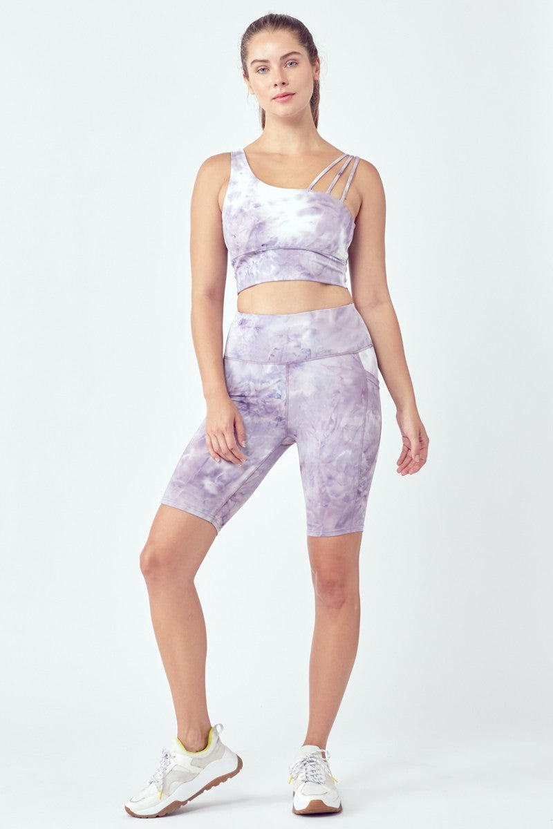 A stylish 2 Piece Asymmetric Shoulder Tie-Dye Biker Set featuring a cropped top and high-waisted biker shorts in vibrant multi-colors.