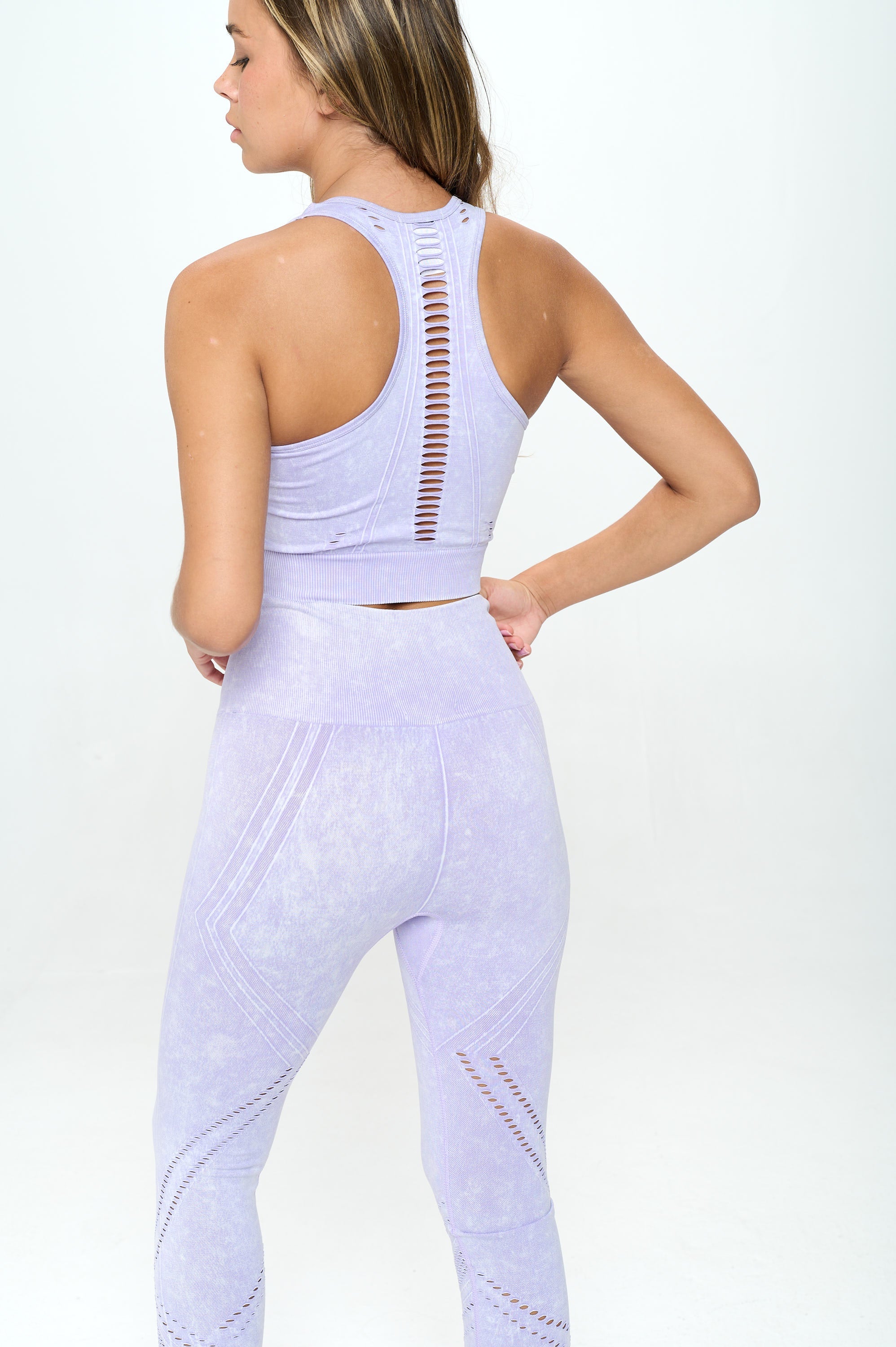 A stylish 2 Piece Seamless Mineral Washed Active Set featuring a cropped top and high-waisted leggings in multiple colors with a ripped pattern.