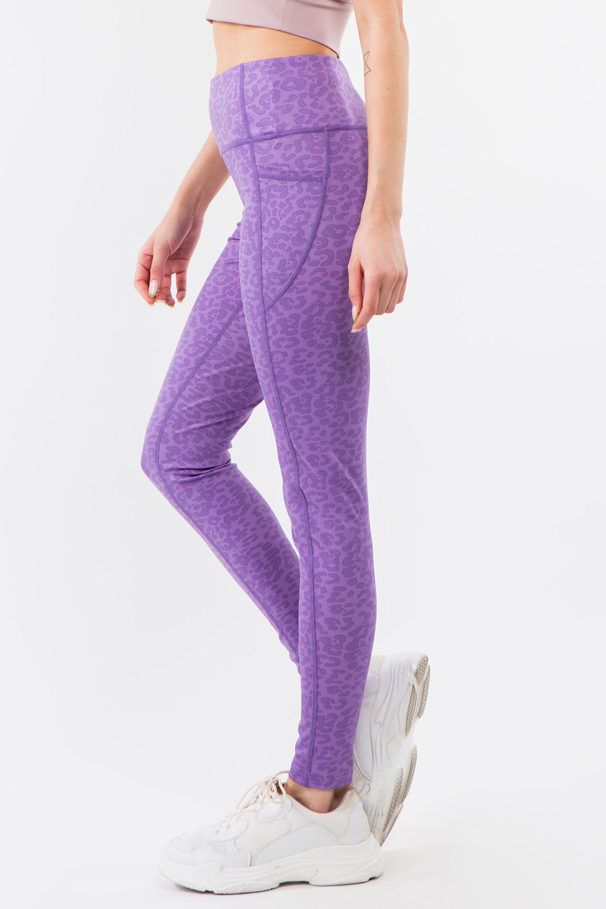 A pair of high-waisted purple leopard leggings displayed on a white background, showcasing their vibrant color and flat seam design.