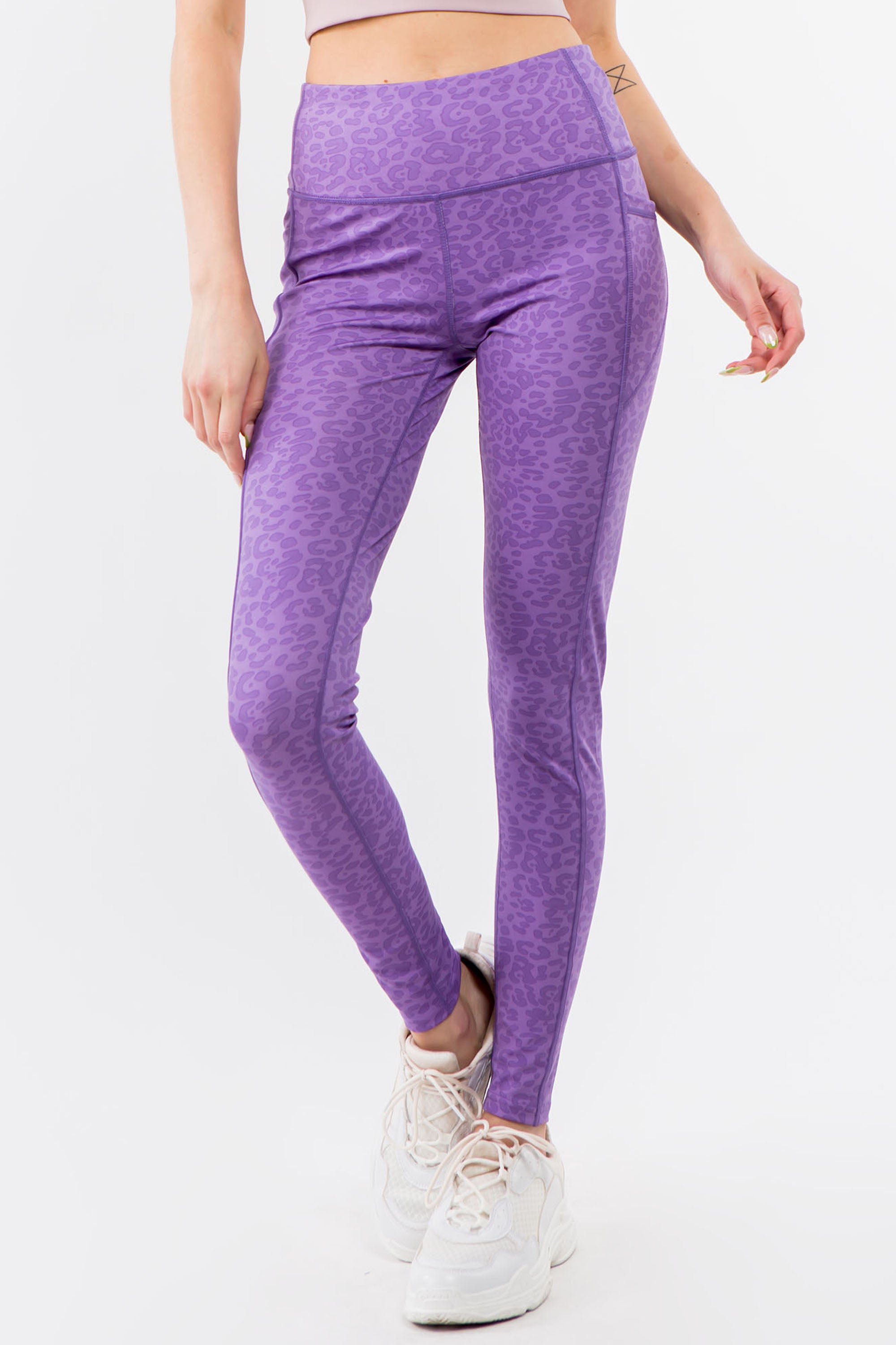 A pair of high-waisted purple leopard leggings displayed on a white background, showcasing their vibrant color and flat seam design.