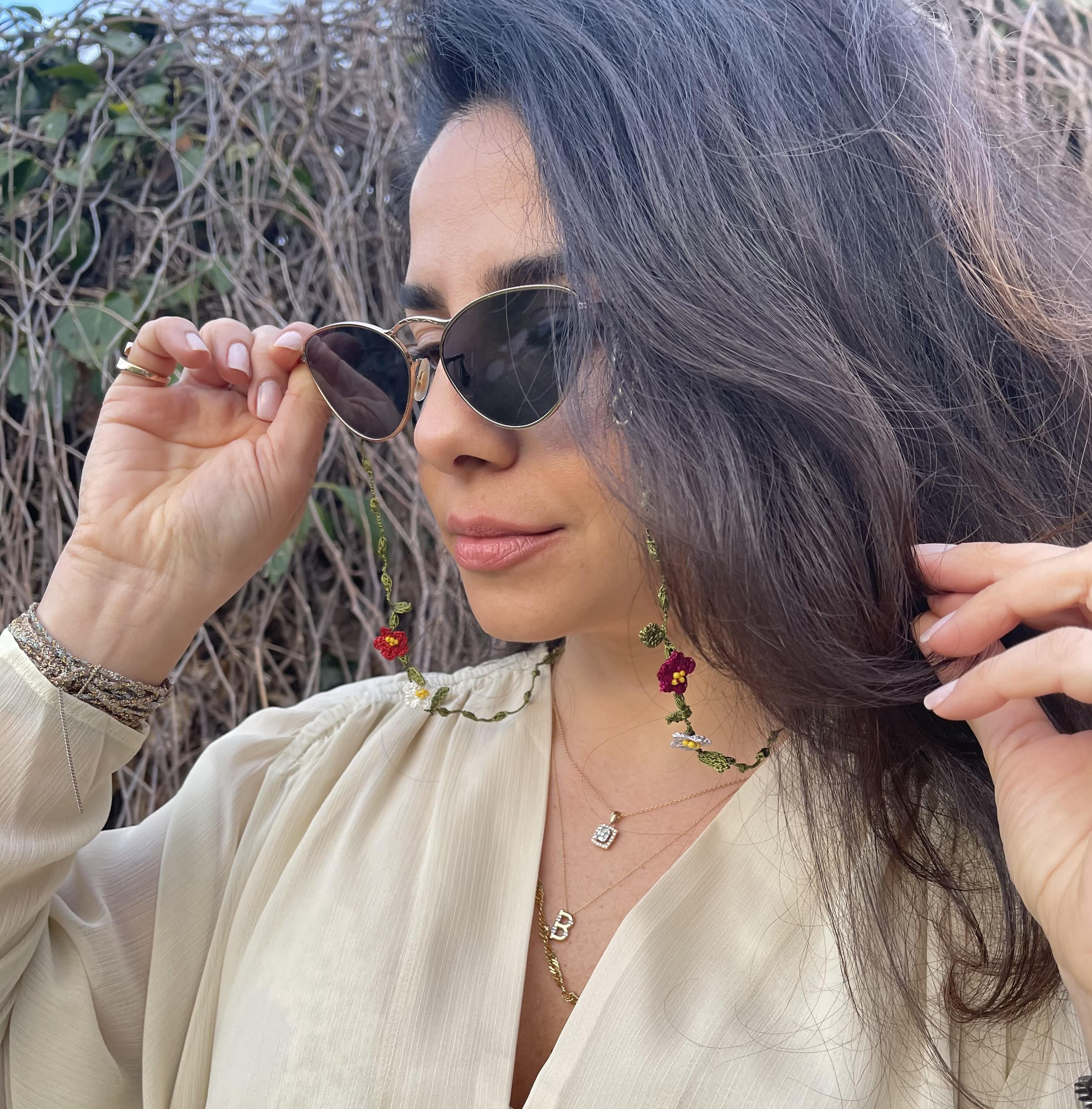 Hand-embroidered Bel Air Sunglasses Chain with silicone tips and lobster fastenings, elegantly displayed in a drawstring pouch.