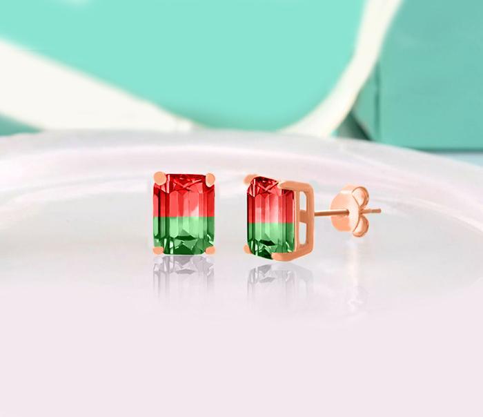 Elegant emerald cut ruby and emerald stud earrings set in 18K rose gold, showcasing vibrant colors and a luxurious design.
