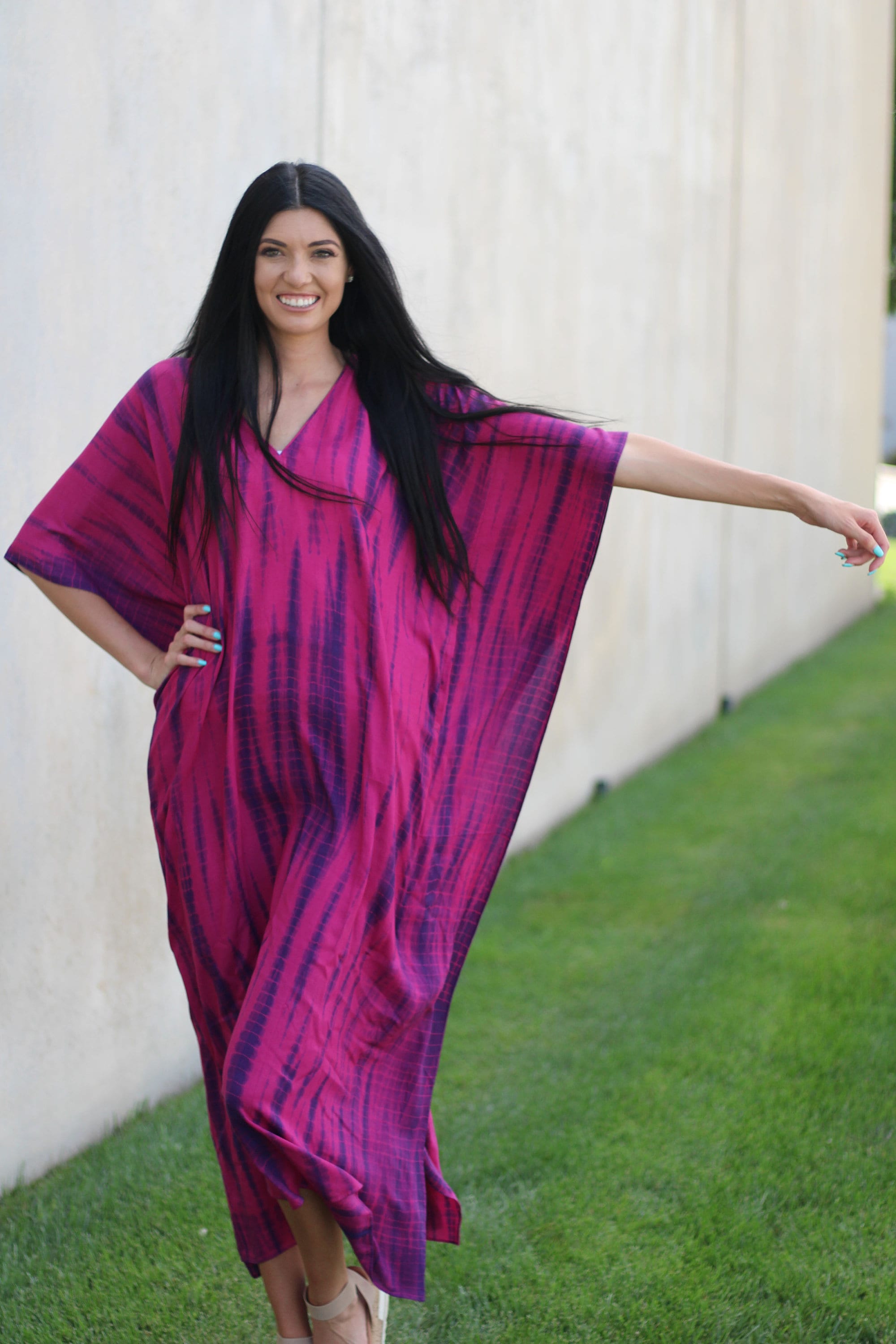 A vibrant tie-dyed kaftan dress in deep pink and navy, featuring a v-shaped neck and spacious pockets, perfect for plus size women.