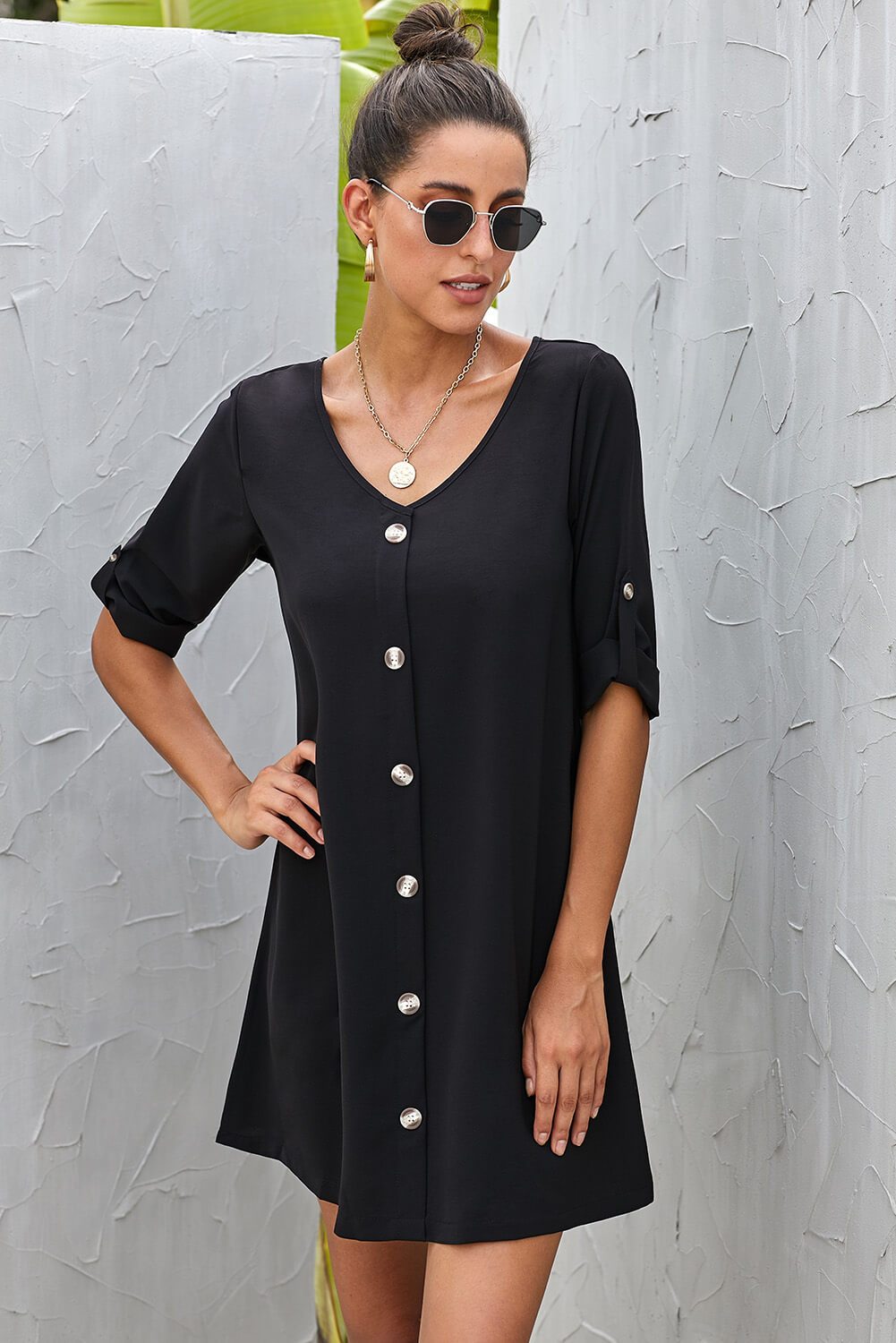 A stylish black casual dress featuring a v-neckline, button front, and roll-up tab sleeves, perfect for spring and autumn wear.