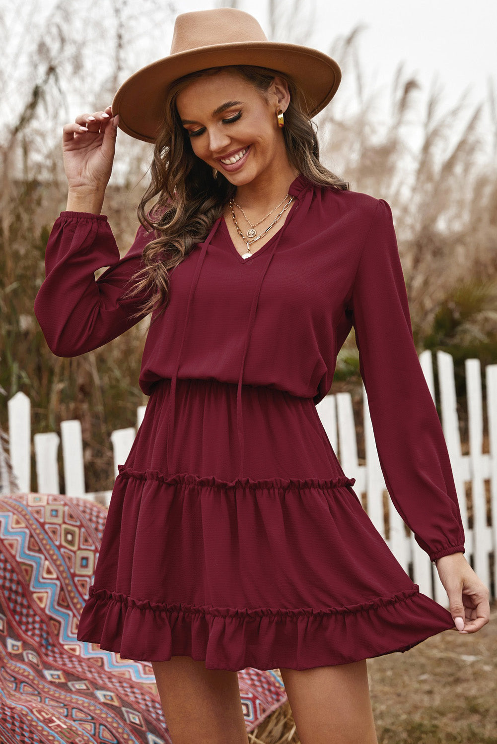 A stylish Wine V Neck Long Sleeve Ruffle Tiered Mini Dress featuring a flattering V-neckline, long puff sleeves, and a tiered ruffle design.