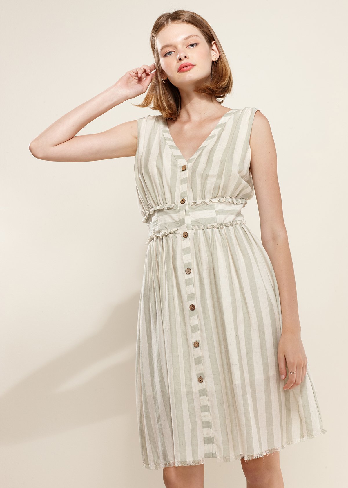 Women's sleeveless button down stripe dress in sage color, featuring a V neckline and frayed hem, perfect for summer outings.