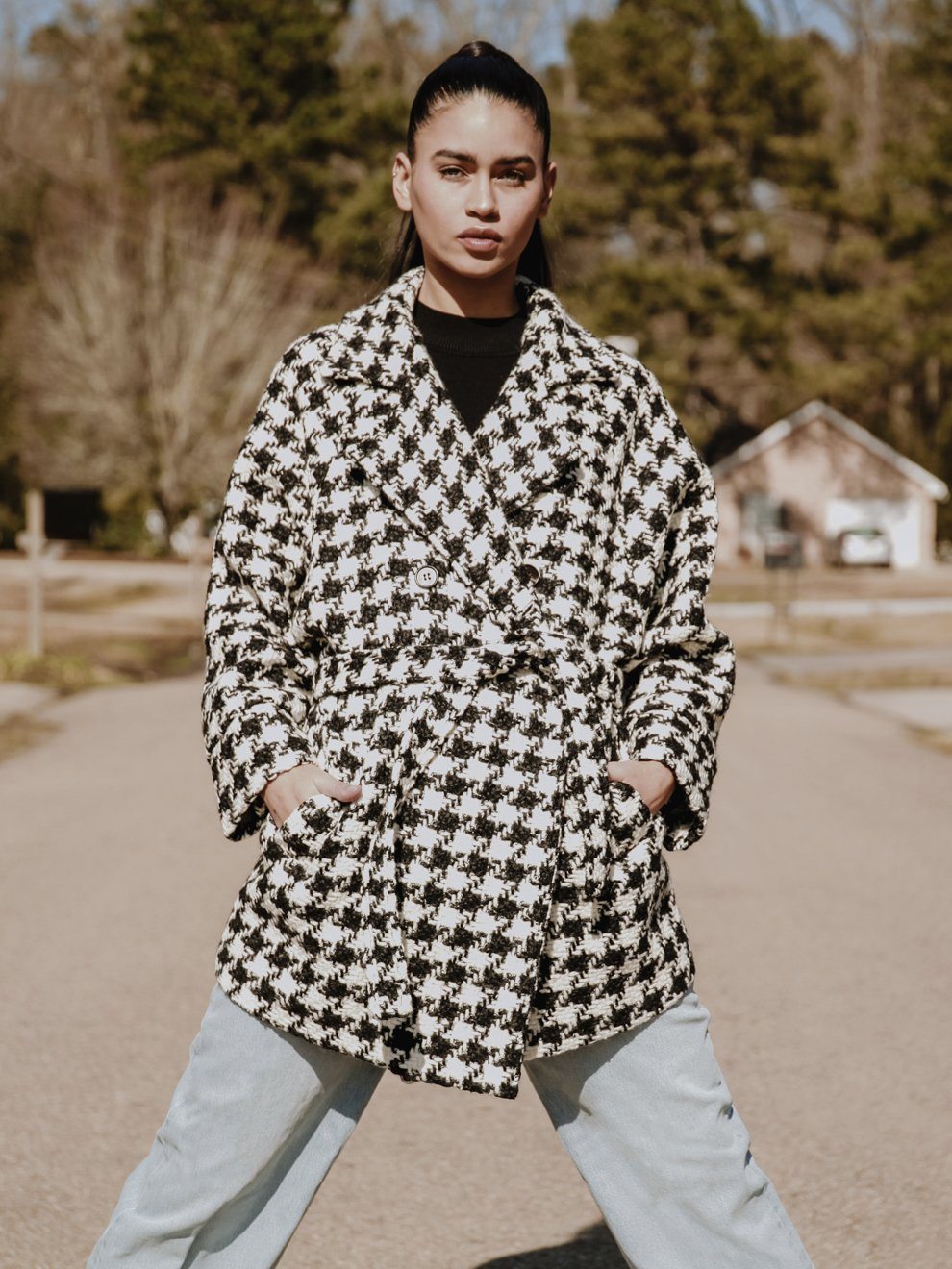 Arlo Oversized Houndstooth Coat featuring a classic print, oversized sleeves, and a detachable belt, styled elegantly over a dress.