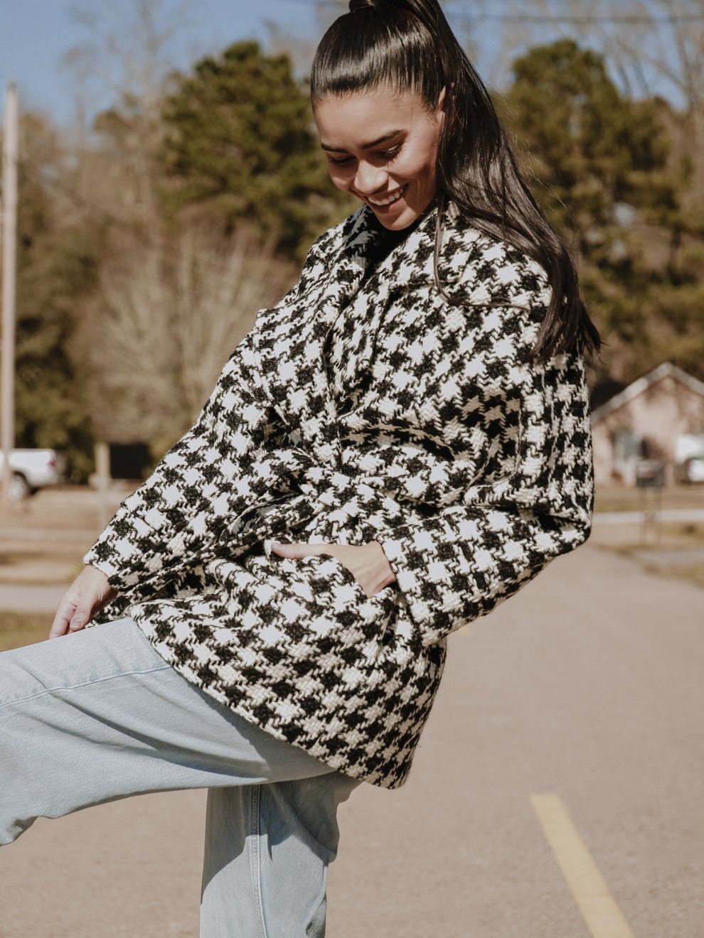 Arlo Oversized Houndstooth Coat featuring a classic print, oversized sleeves, and a detachable belt, styled elegantly over a dress.