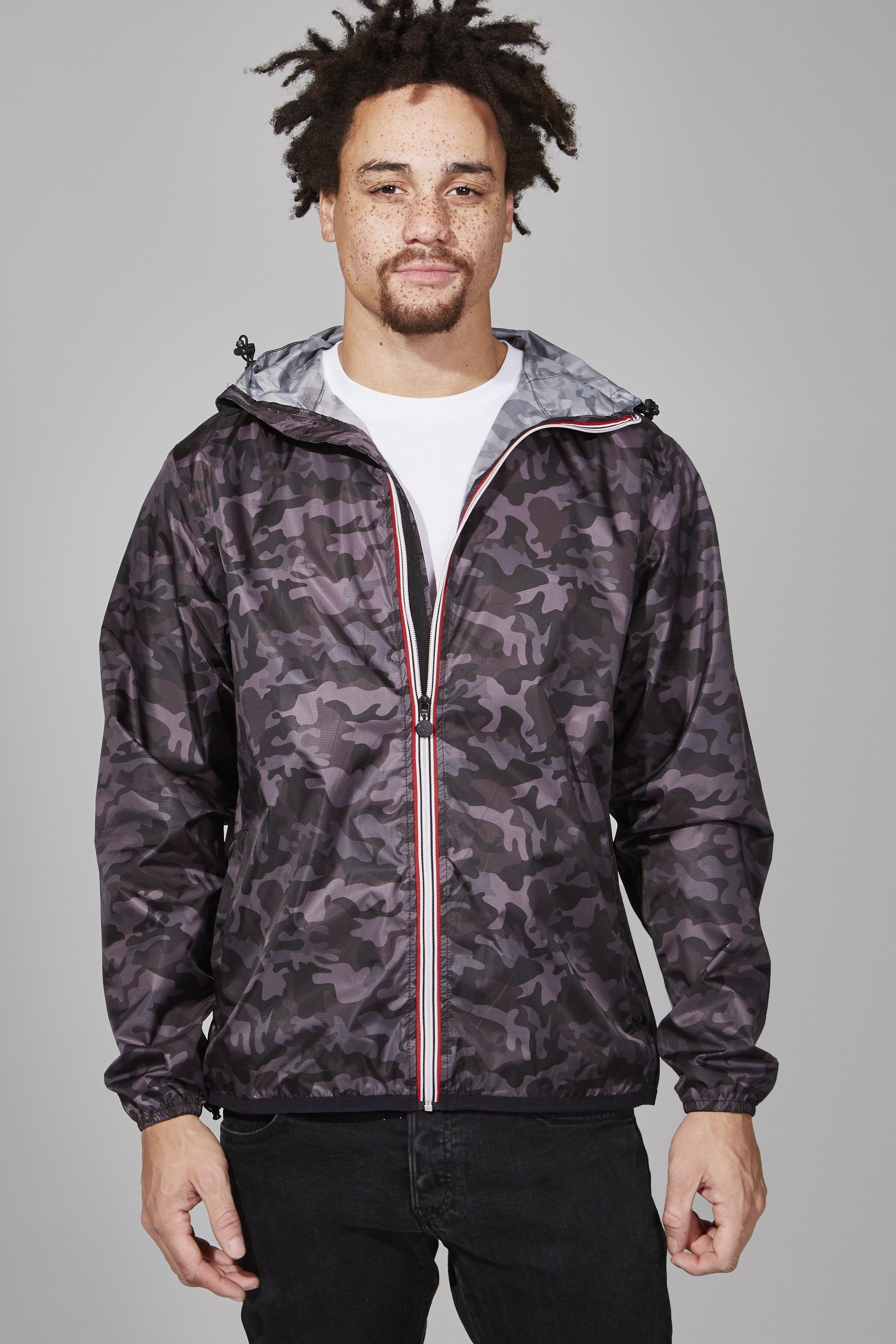 Black camo full zip packable rain jacket displayed on a hanger, showcasing its stylish design and functional features.