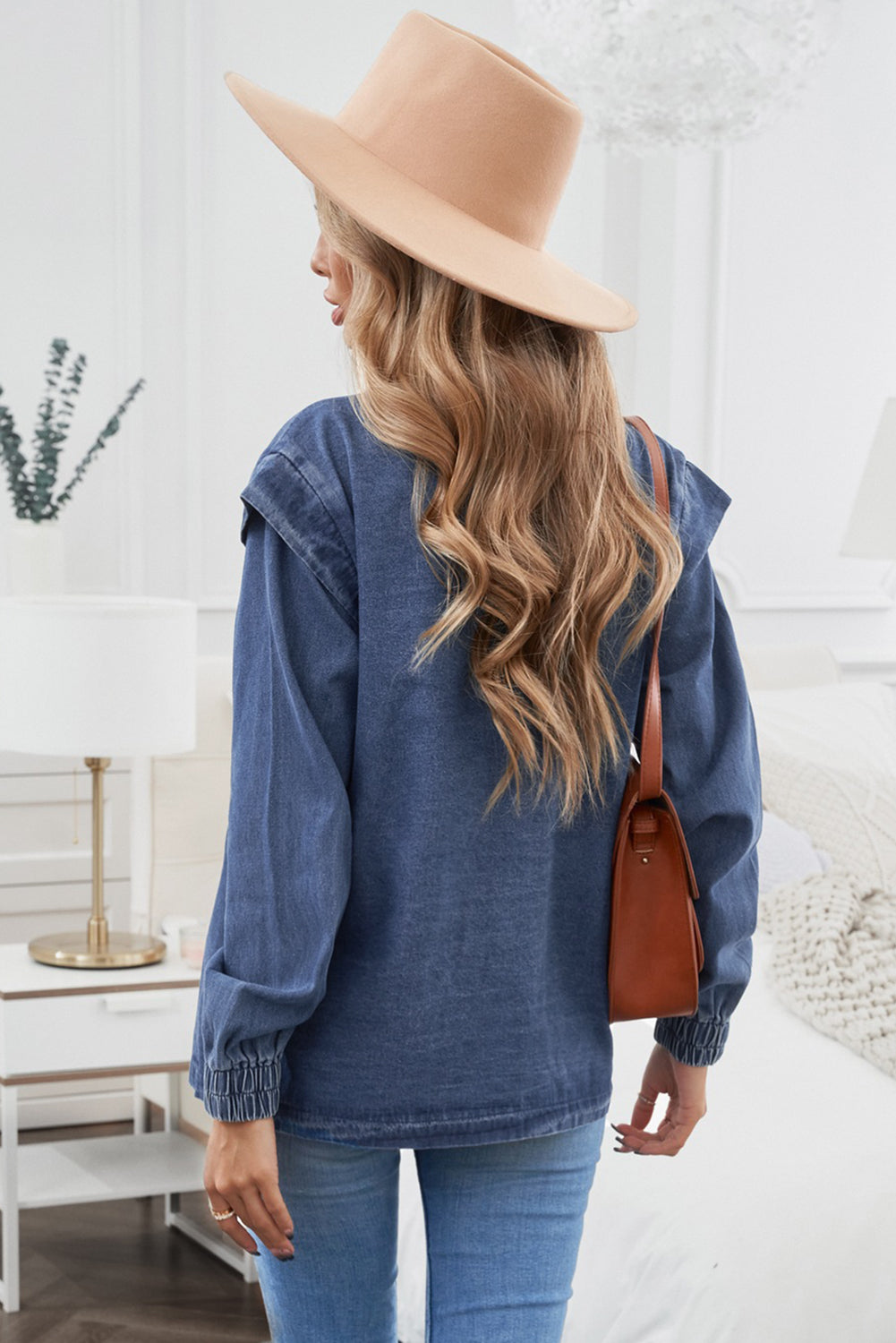 A stylish blue denim jacket featuring elastic cuffs, button closure, and unique patchwork details on the sleeves, perfect for casual wear.