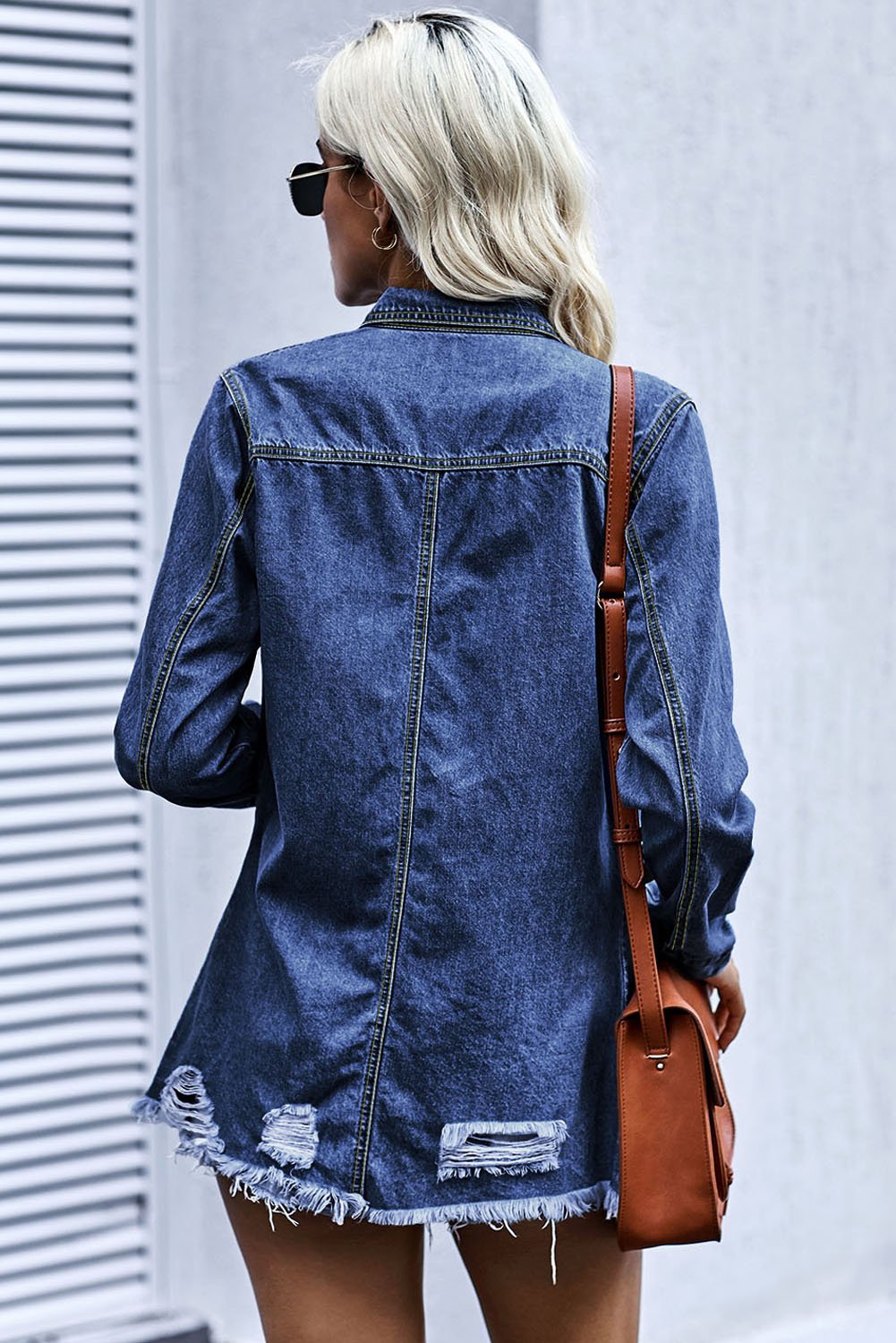 Dark blue jeans shacket with elegant collar and distressed design, featuring button closure and pockets.
