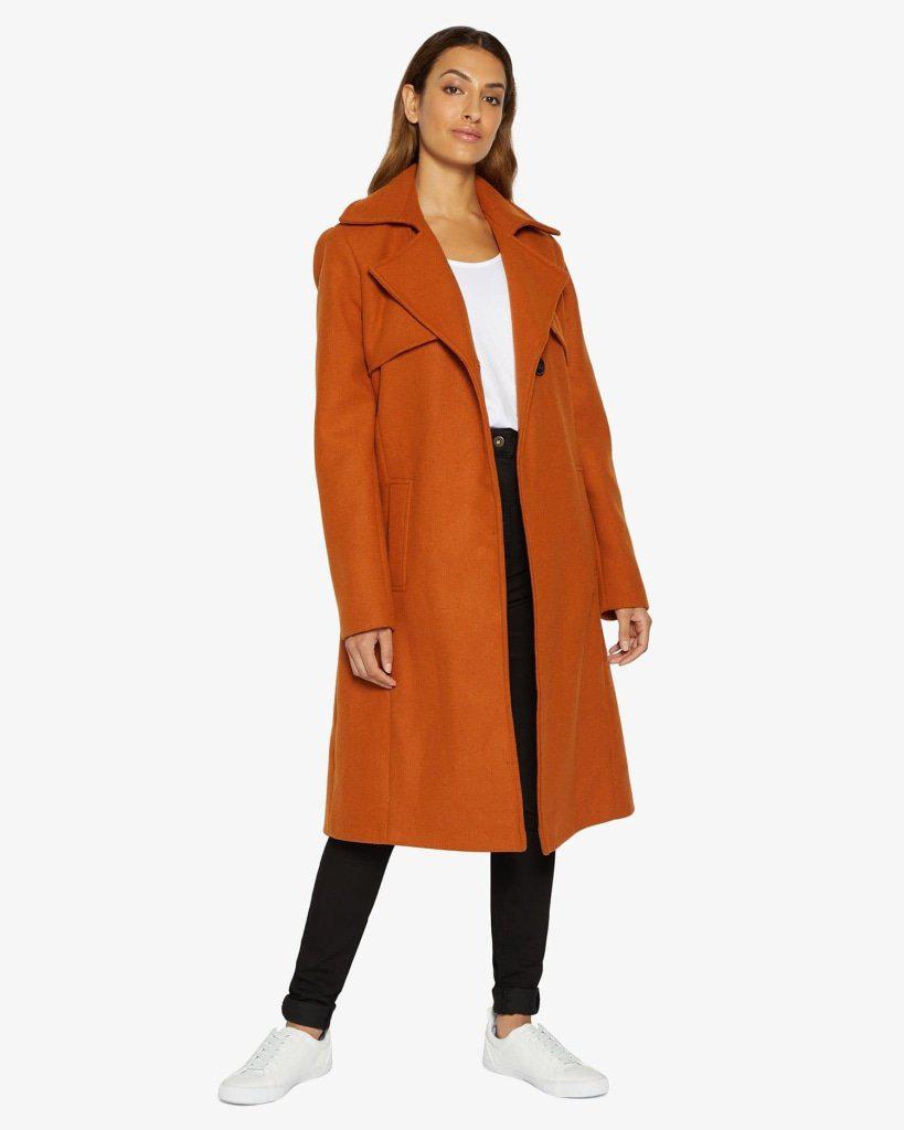 Dina Lapel Collar Duster Coat with Belt, featuring a stylish design, lapel collar, and two side pockets, made from a luxurious wool blend.