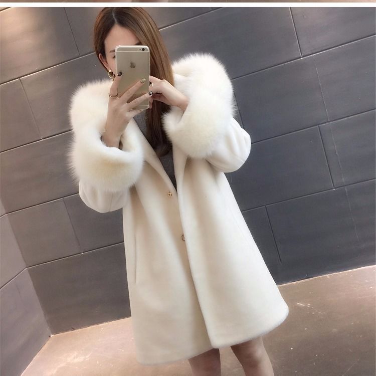 A stylish women's winter coat made of faux fur, featuring a hood and mid-length design, perfect for cold weather.