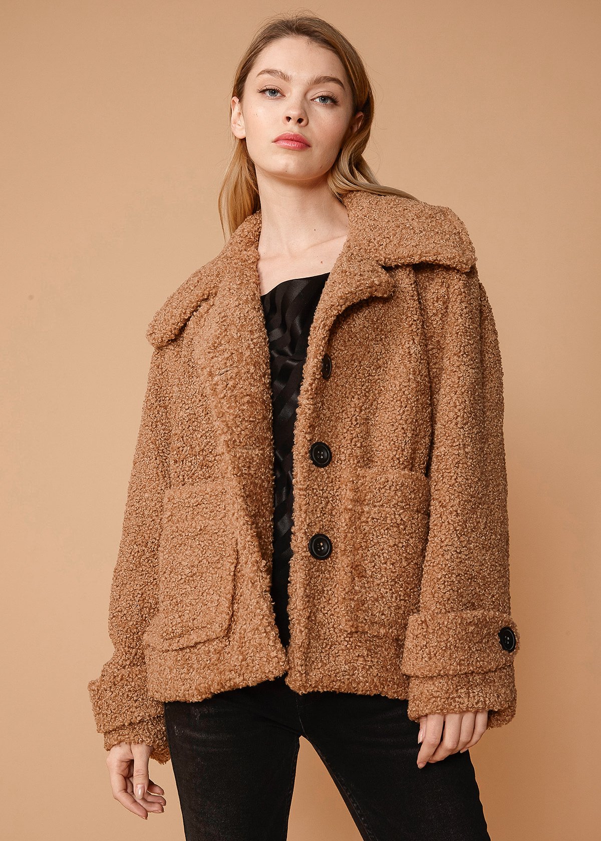 Women's brown faux shearling coat with two front pockets, lined interior, and stylish design.