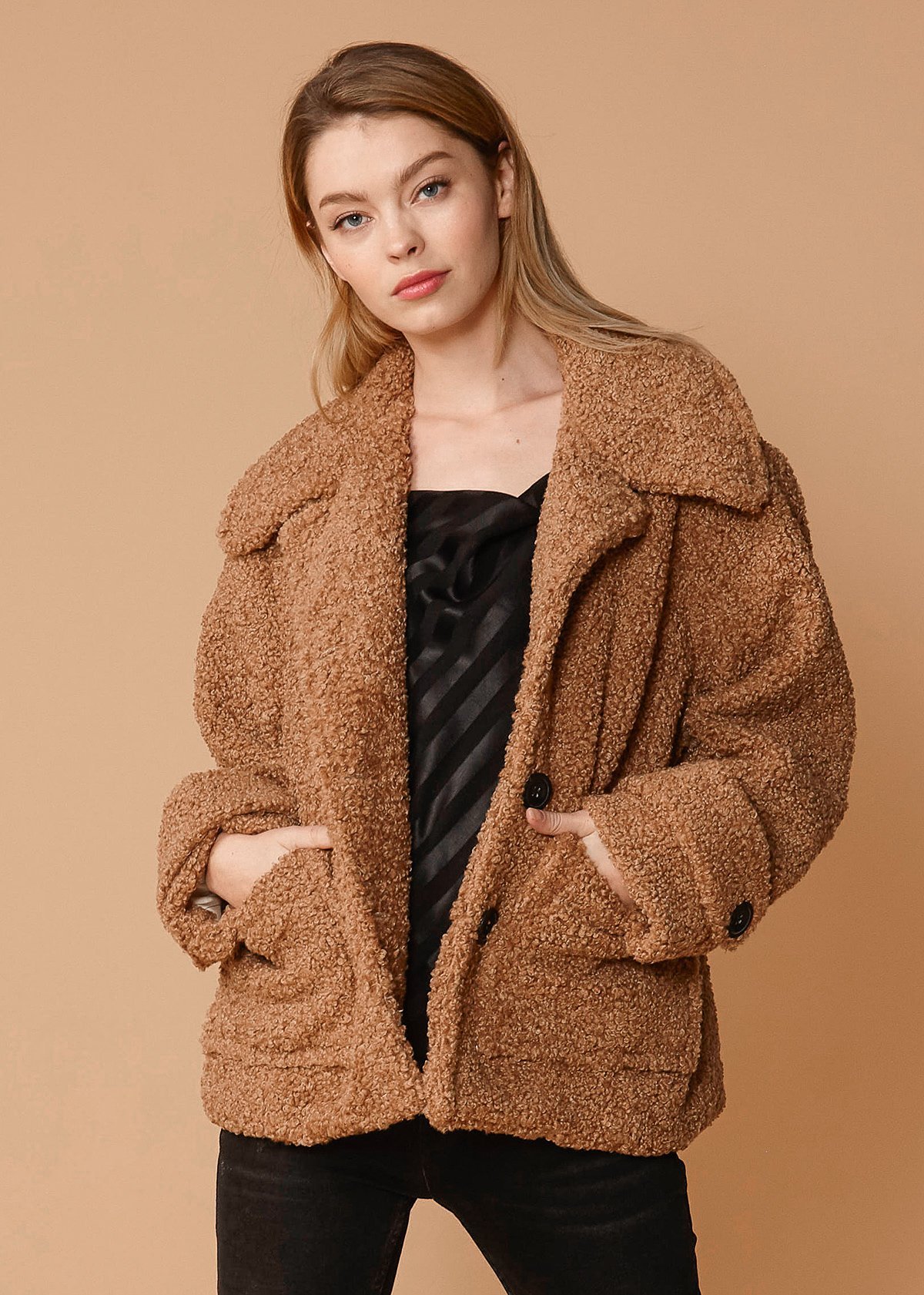 Women's brown faux shearling coat with two front pockets, lined interior, and stylish design.