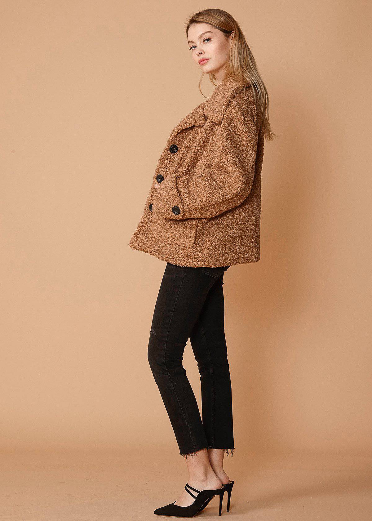 Women's brown faux shearling coat with two front pockets, lined interior, and stylish design.