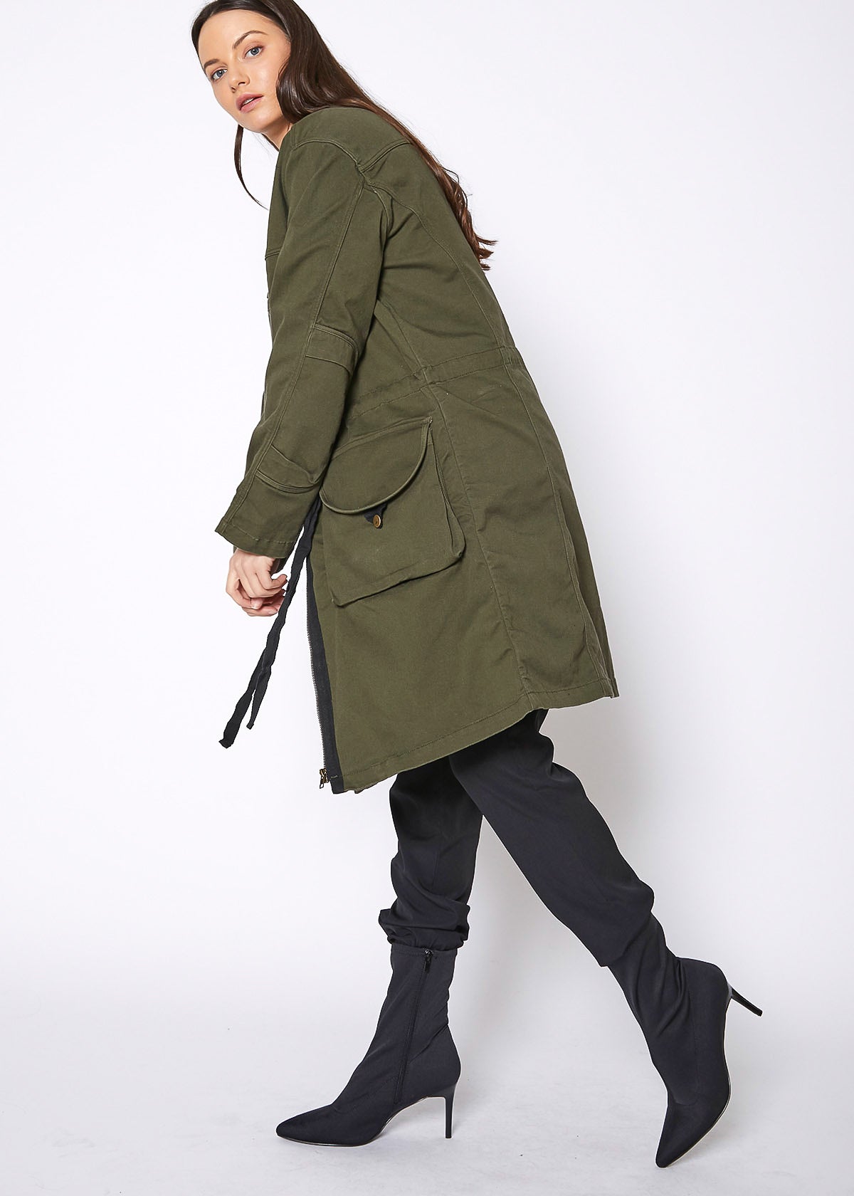Women's olive zip up long utility jacket with adjustable drawstring waist, showcasing a stylish and functional design.