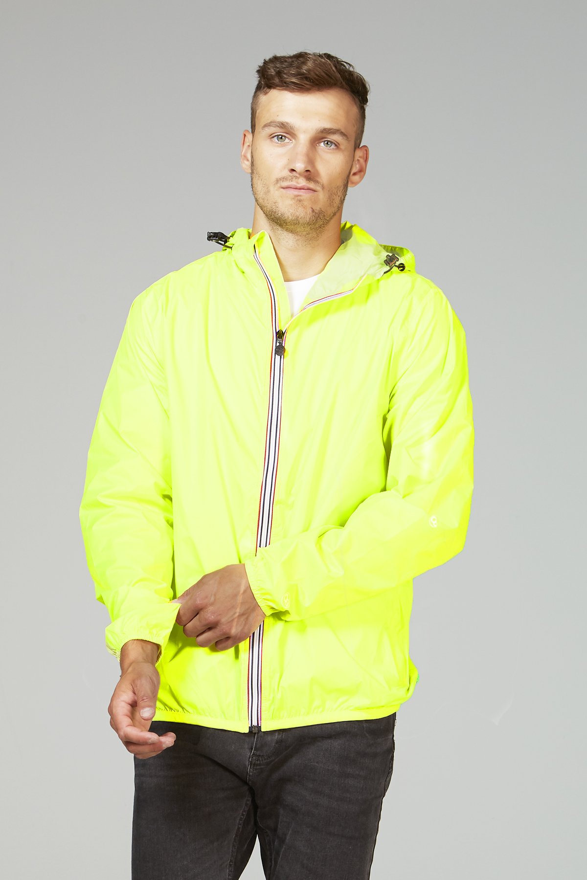A vibrant yellow fluo full zip packable rain jacket, showcasing its waterproof fabric and packable design, ideal for outdoor activities.