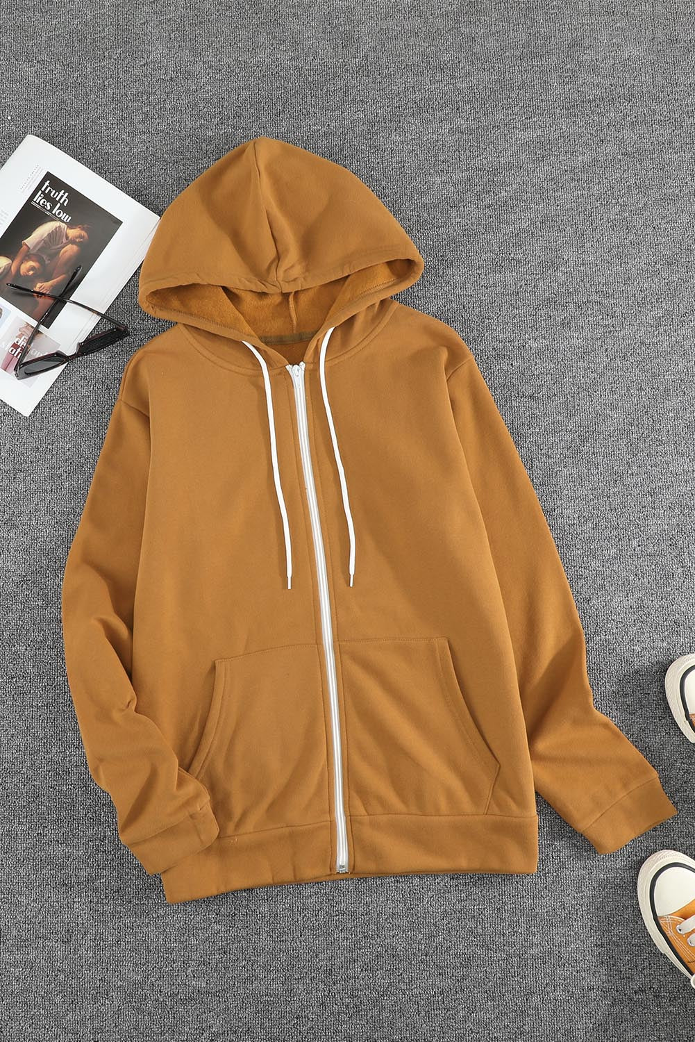 A stylish brown zip-up hoodie jacket with pockets and a drawstring hood, perfect for casual wear.