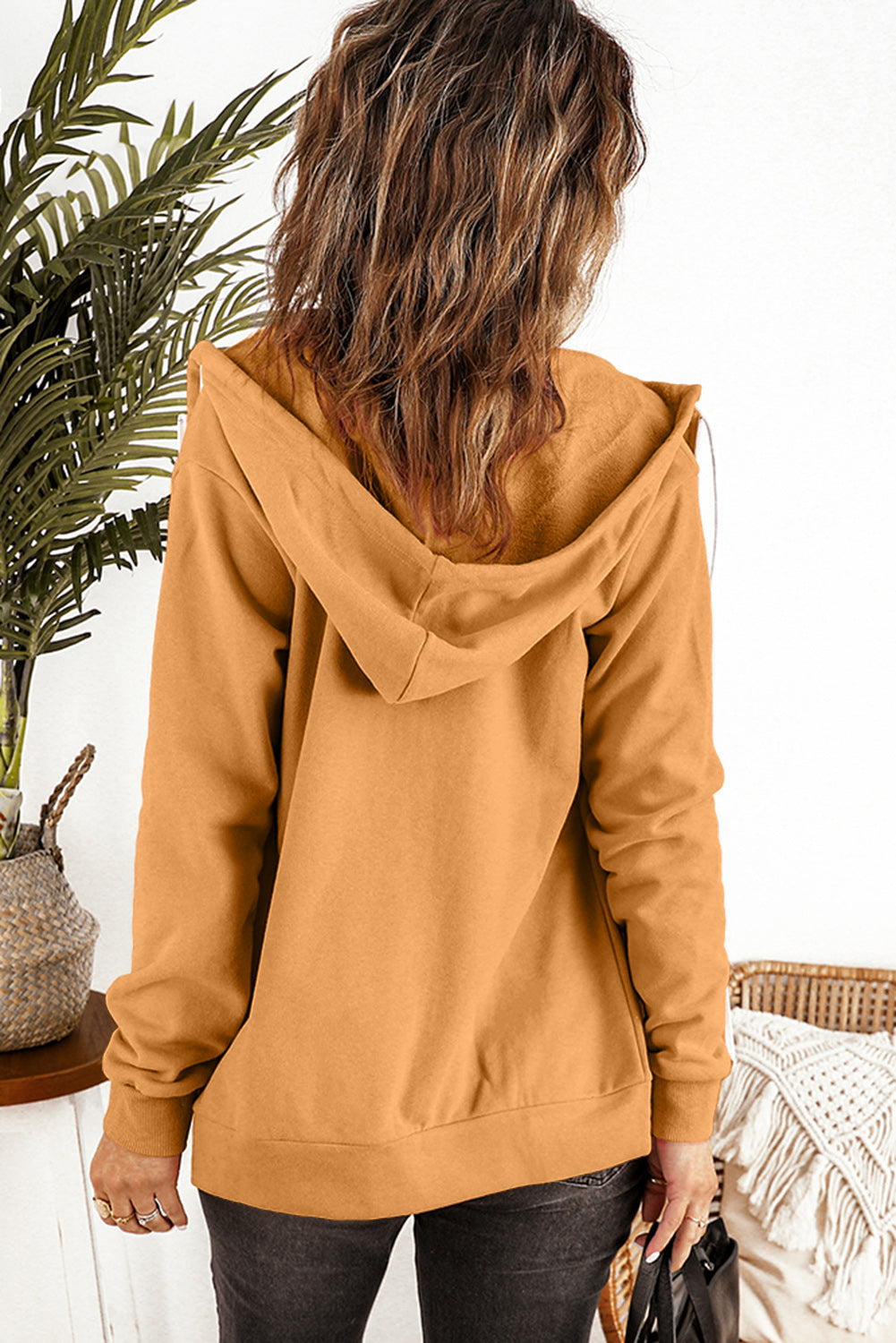 A stylish brown zip-up hoodie jacket with pockets and a drawstring hood, perfect for casual wear.