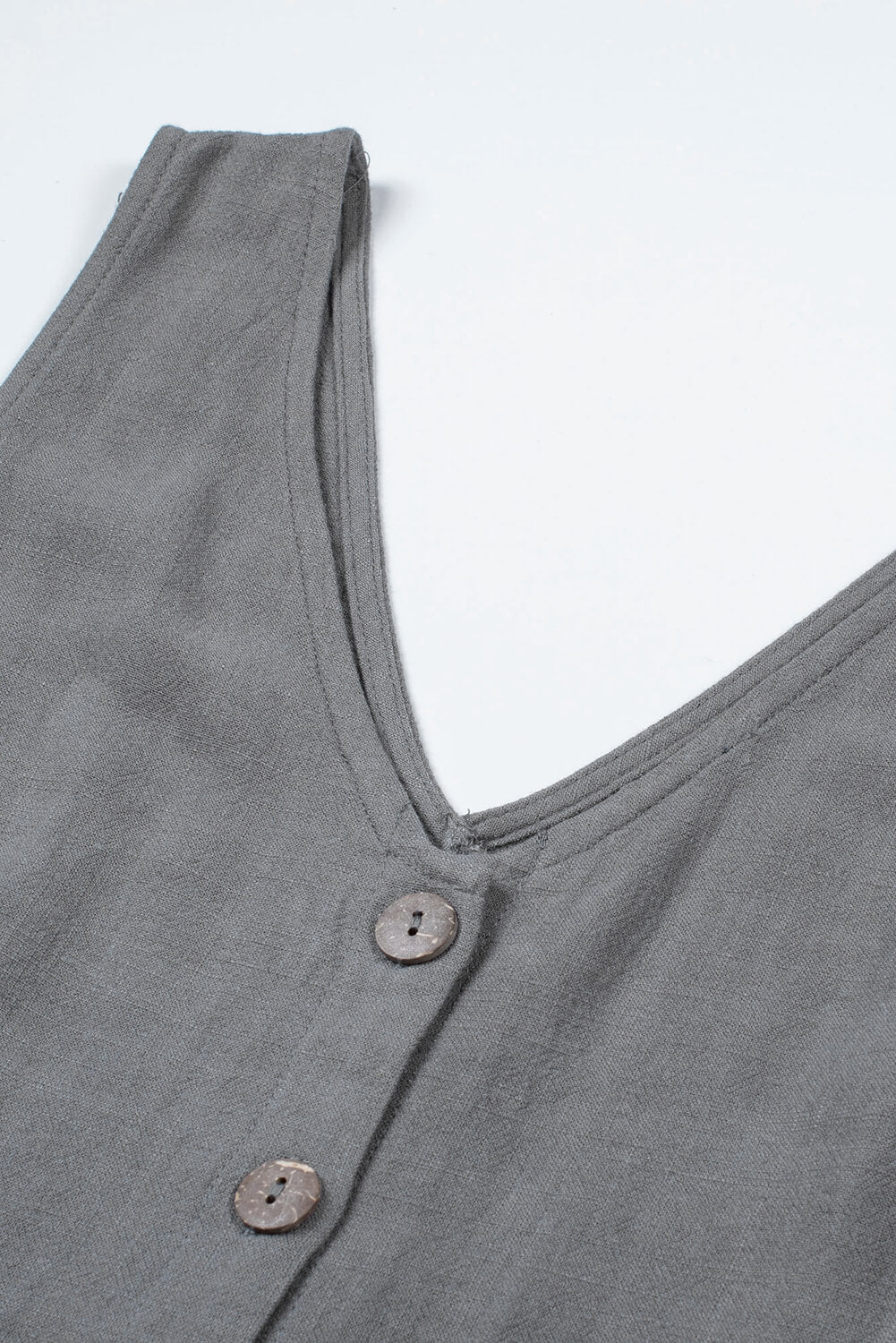 Casual gray sleeveless romper featuring a v-neck, button details, and a stylish waist belt, perfect for summer outings.