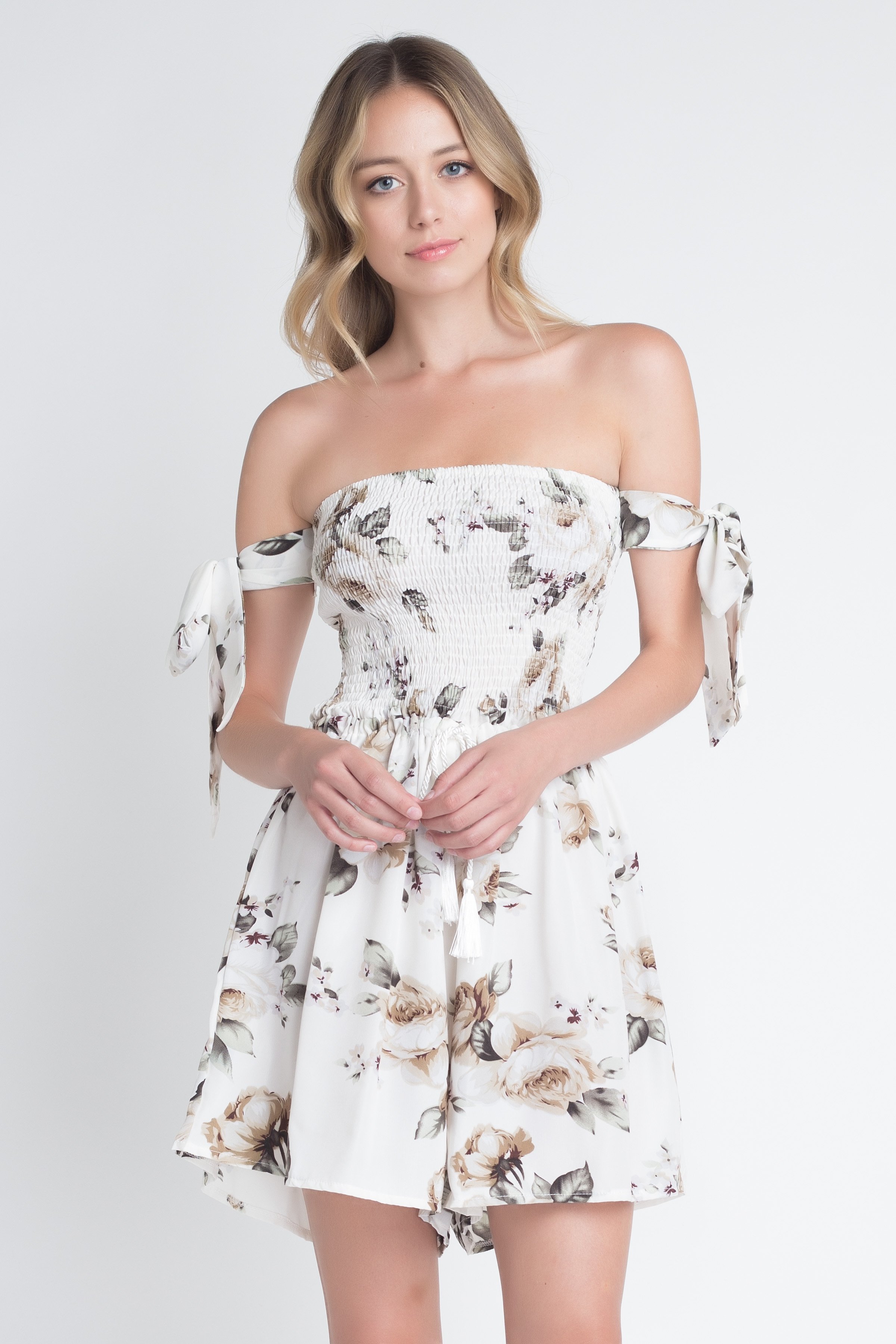 A stylish Women's Off Shoulder Smocked Floral Tie Romper featuring a vibrant floral print and adjustable tie sleeves, perfect for summer outings.