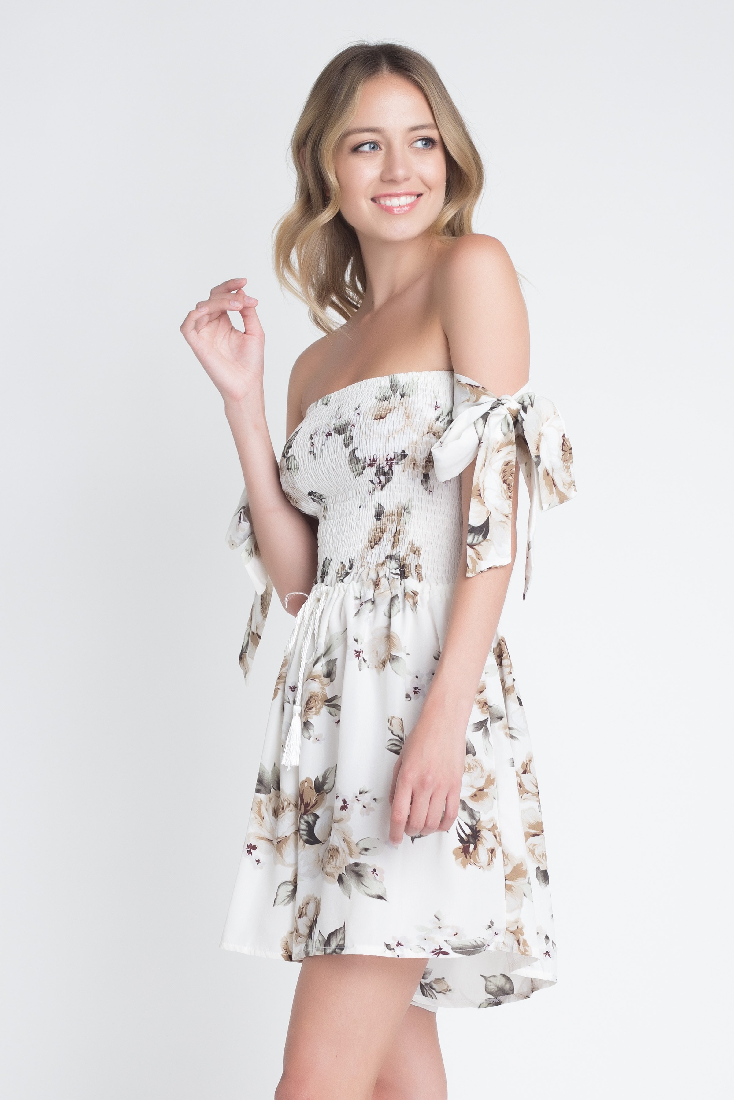 A stylish Women's Off Shoulder Smocked Floral Tie Romper featuring a vibrant floral print and adjustable tie sleeves, perfect for summer outings.