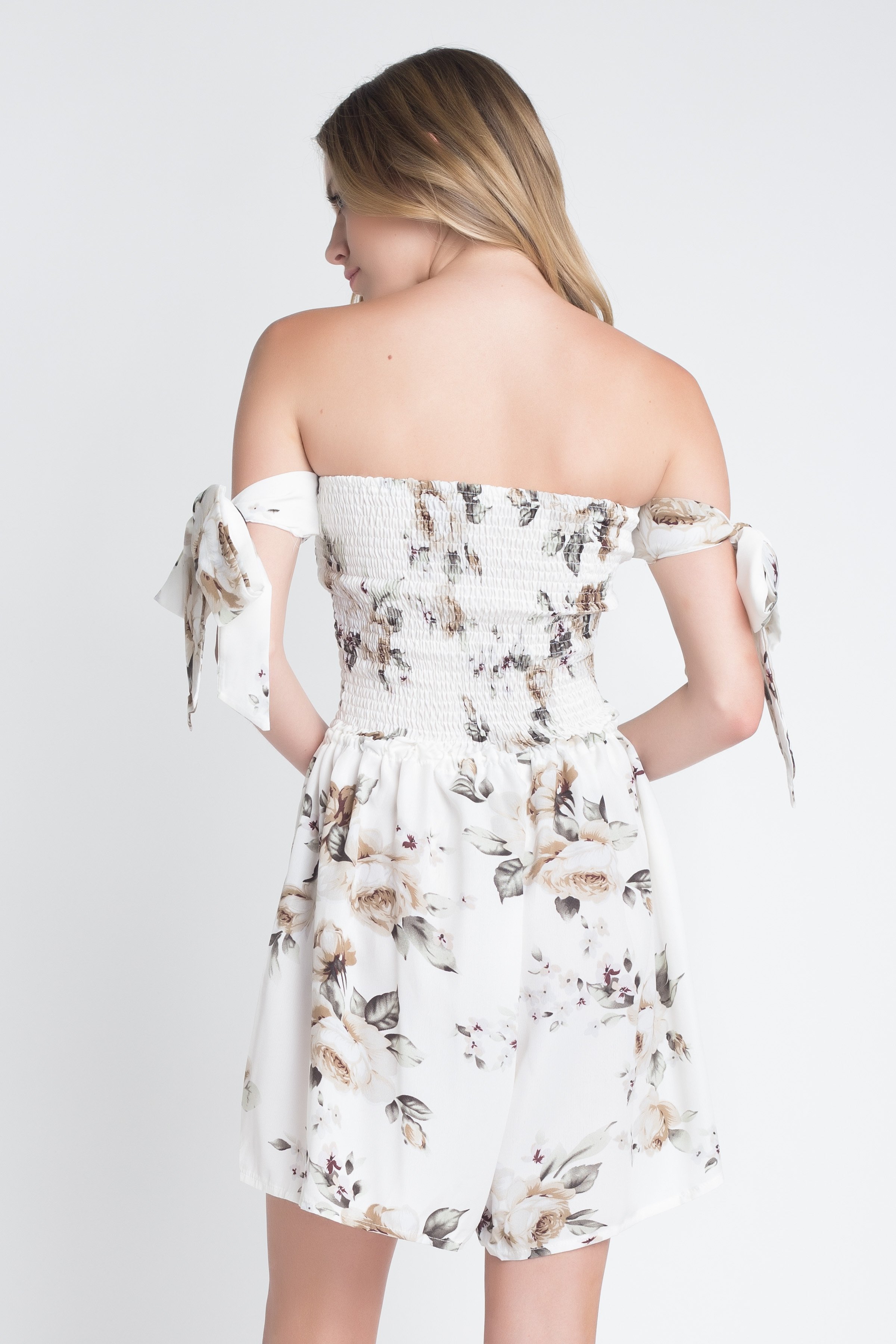 A stylish Women's Off Shoulder Smocked Floral Tie Romper featuring a vibrant floral print and adjustable tie sleeves, perfect for summer outings.