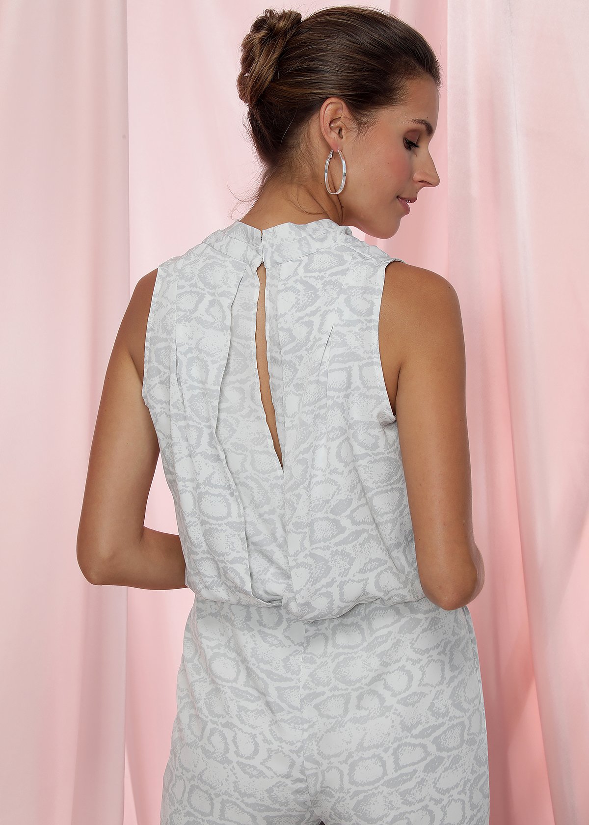 Women's sleeveless jumpsuit featuring a V-neck and open back in ivory silver print, perfect for stylish occasions.