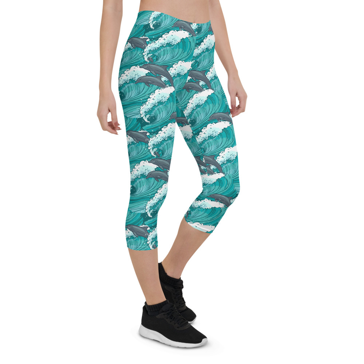 A pair of Women's Dolphin and Waves Capri Leggings featuring vibrant dolphin and wave graphics, designed for comfort and performance.