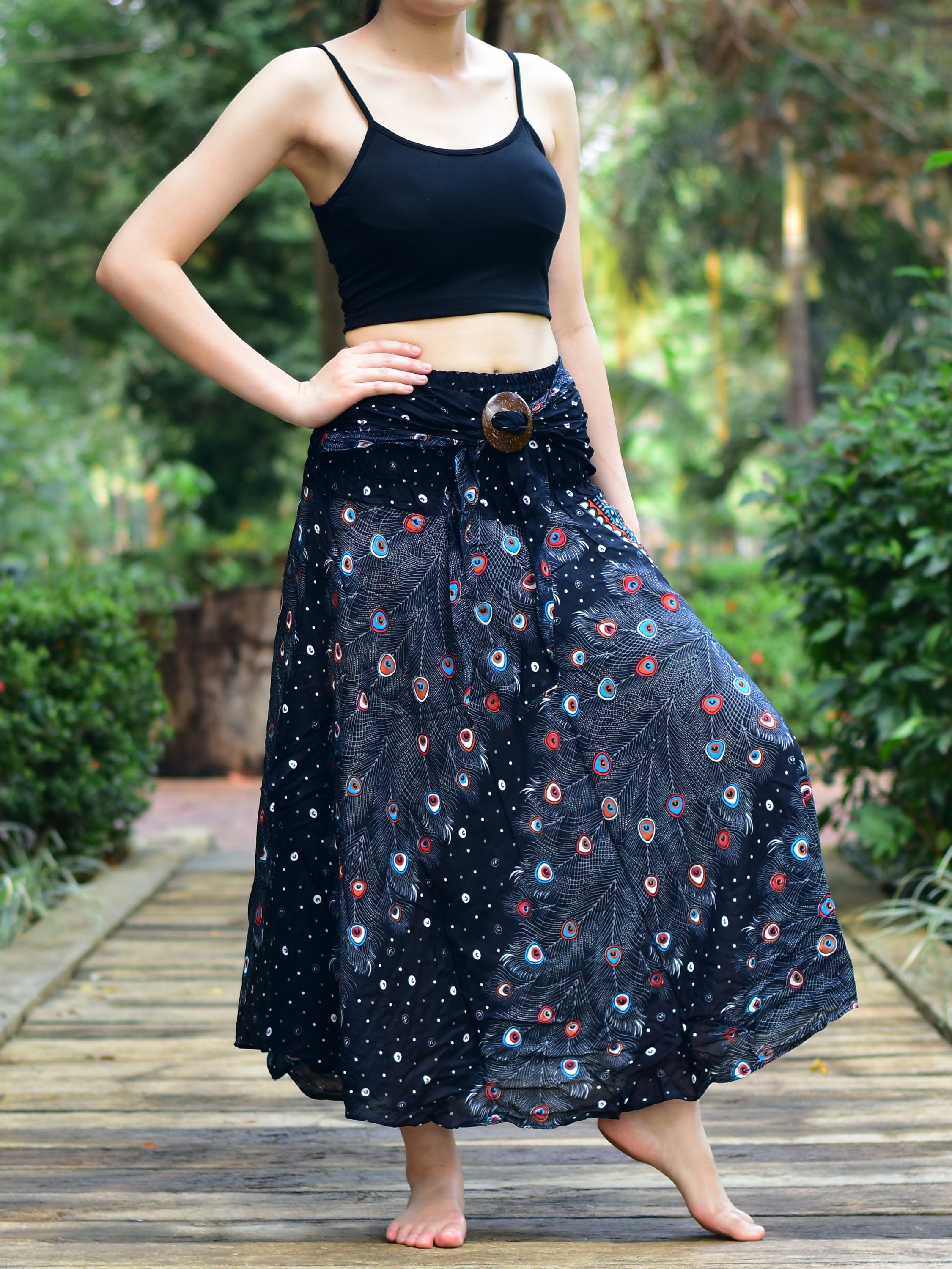 Bohotusk Black Peacock Long Skirt featuring a coconut buckle and elasticated smocked waist, styled elegantly on a model.
