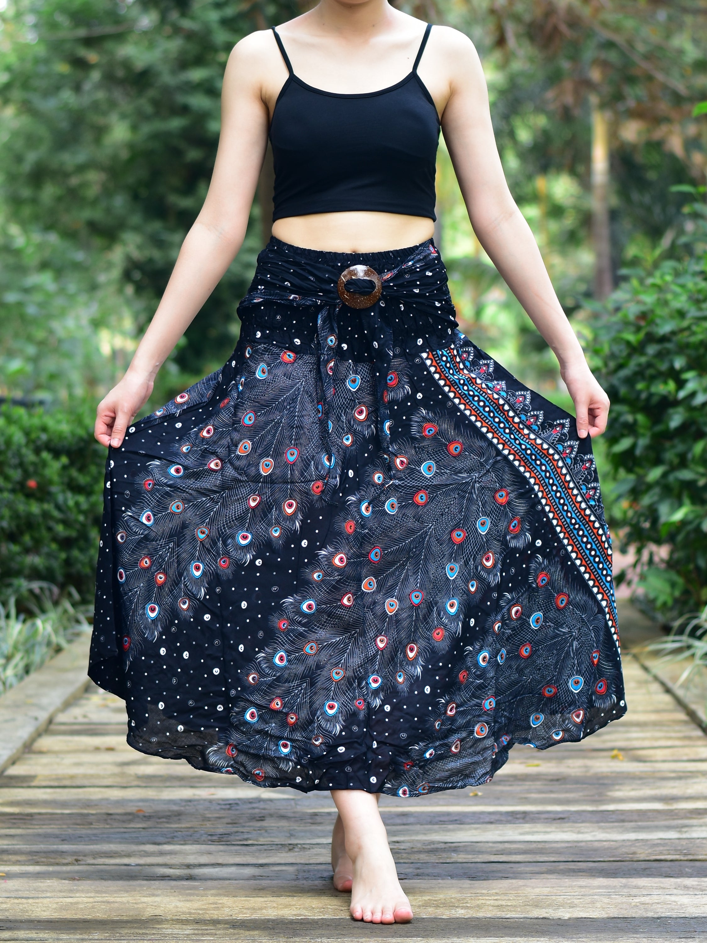 Bohotusk Black Peacock Long Skirt featuring a coconut buckle and elasticated smocked waist, styled elegantly on a model.