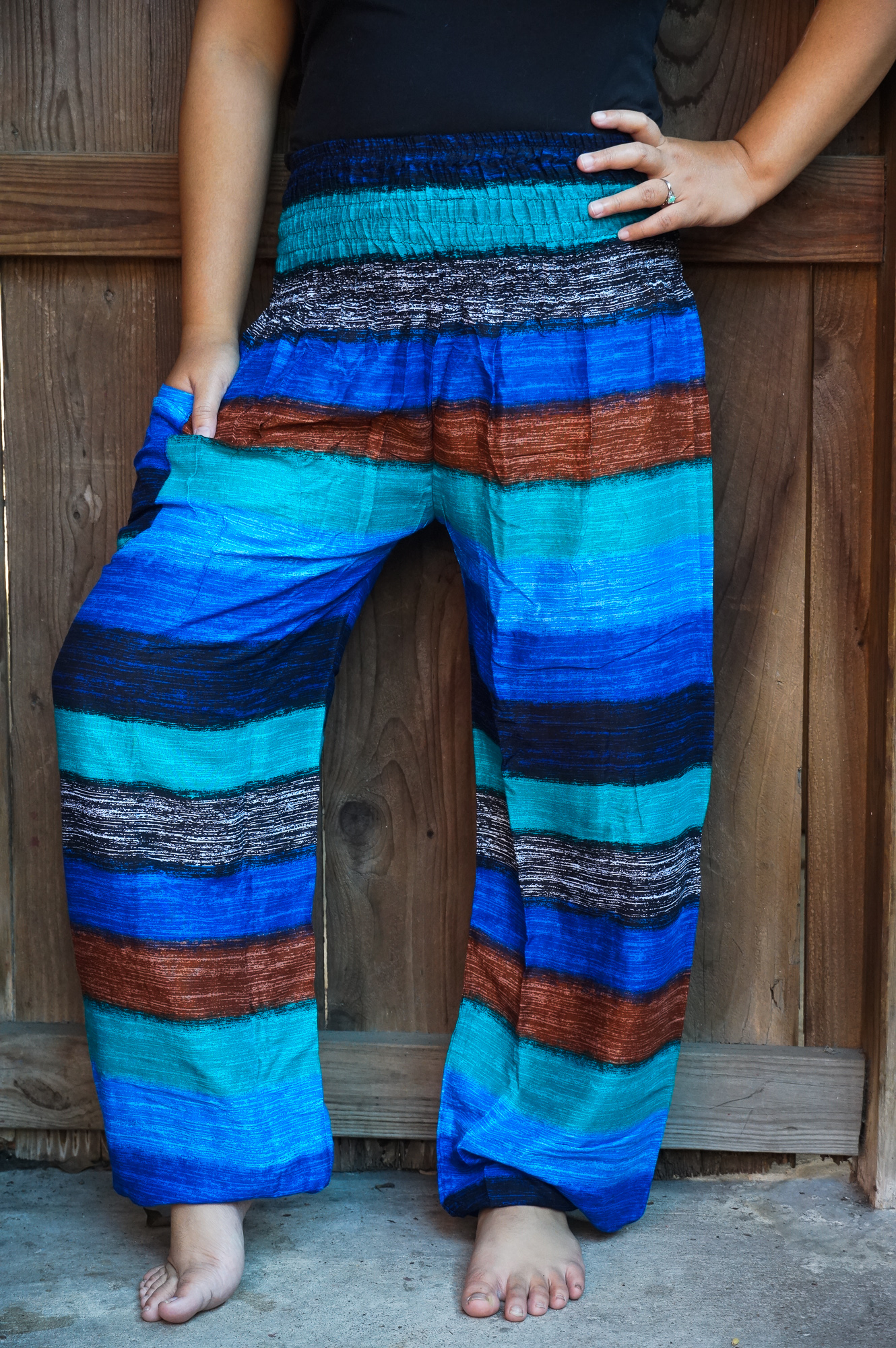 A pair of colorful Stripe Boho Pants made from lightweight rayon, featuring an elastic waist and ankle, with a side pocket, perfect for yoga and casual wear.