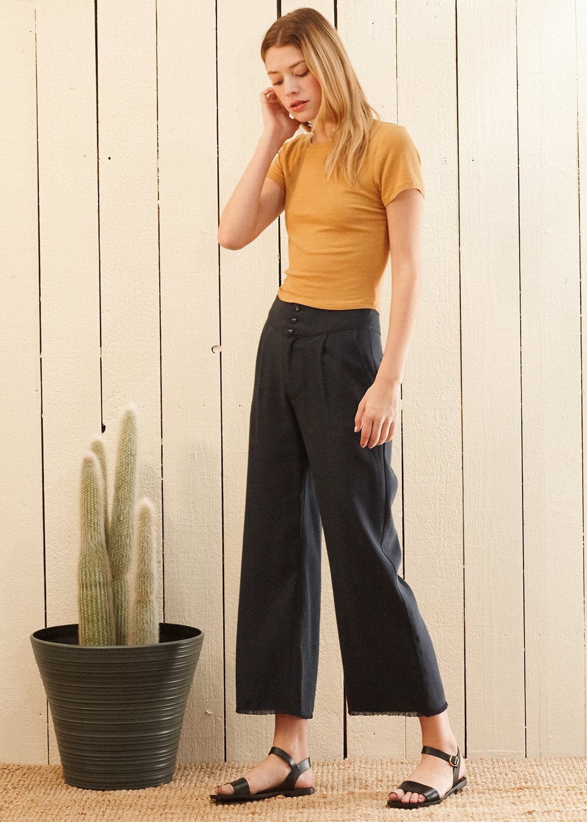 Women's navy cropped pants featuring a fringe raw hem and high-waisted design, made from soft Tencel fabric.