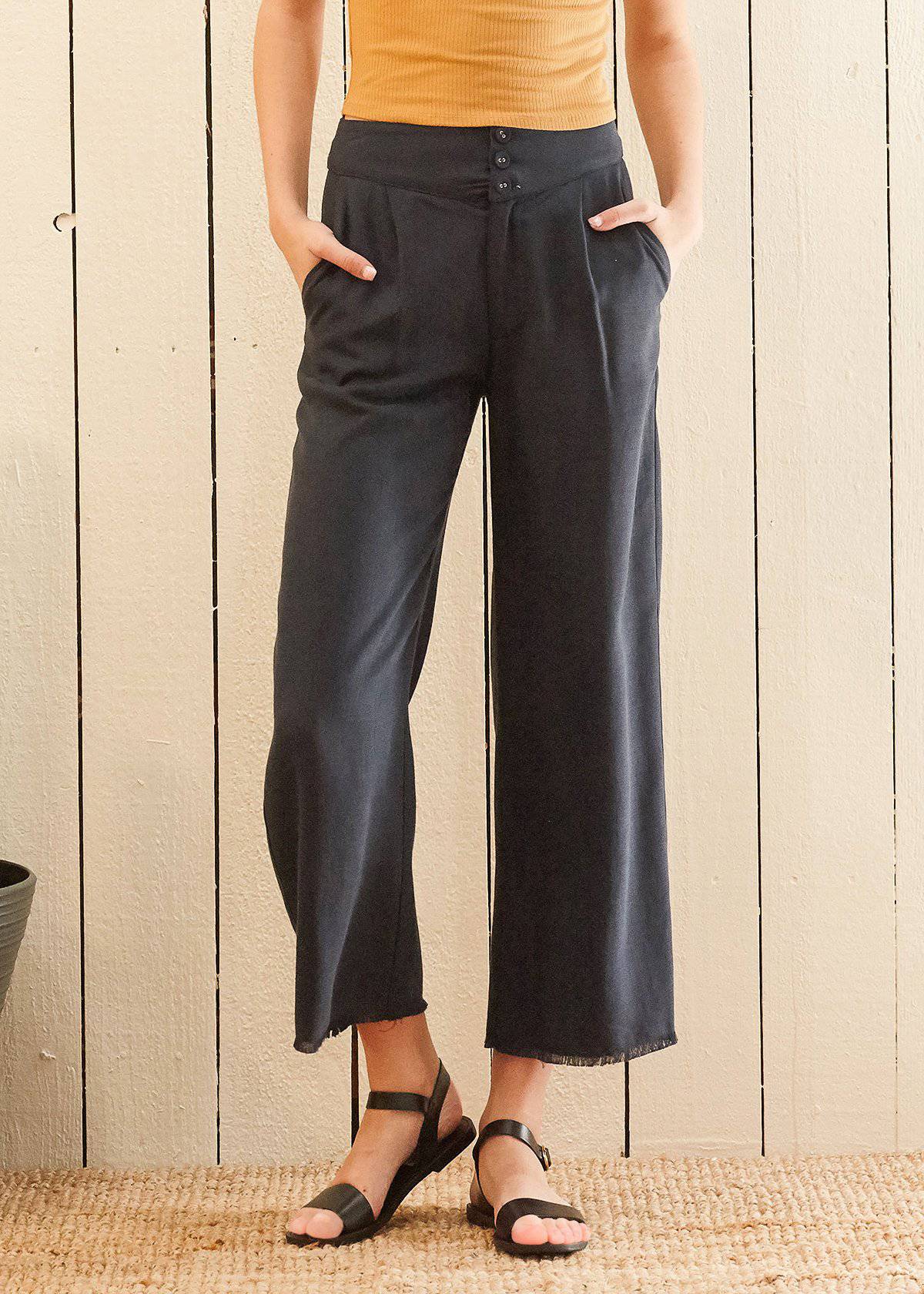Women's navy cropped pants featuring a fringe raw hem and high-waisted design, made from soft Tencel fabric.