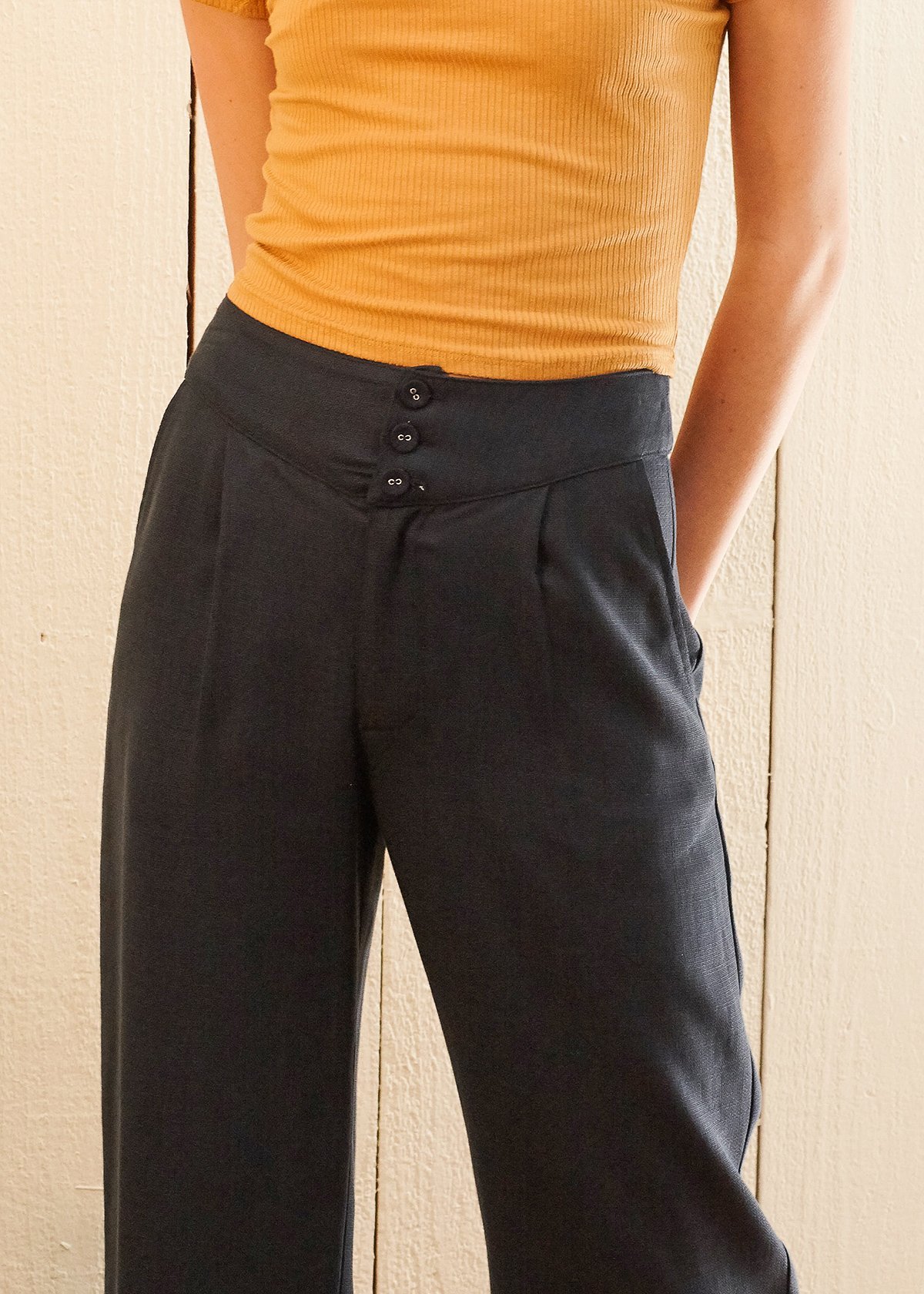Women's navy cropped pants featuring a fringe raw hem and high-waisted design, made from soft Tencel fabric.