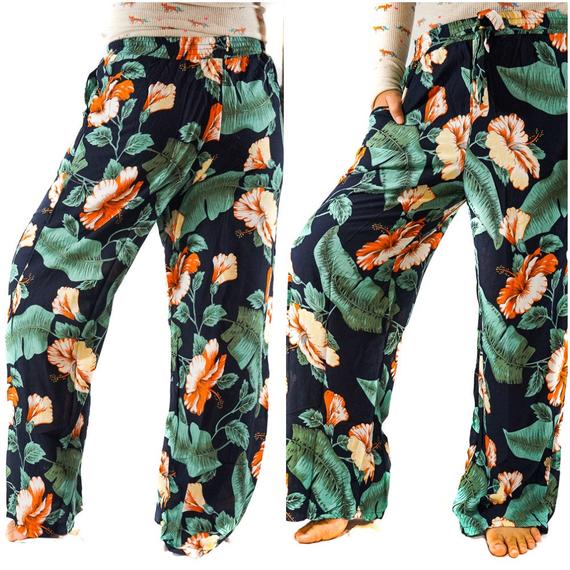 A pair of XS-M Leaf Print Pants for women, featuring a vibrant leaf pattern, drawstring waist, and two side pockets, made from lightweight rayon fabric.